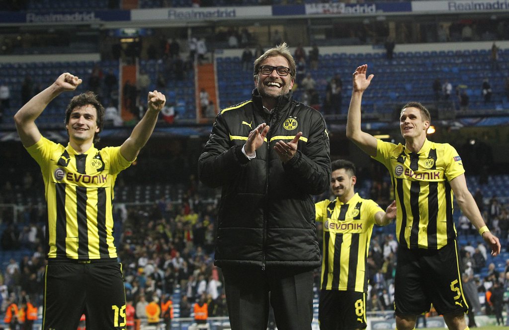 epa03683139 Borussia Dortmund's head coach J?rgen Klopp (c) and his players celebrate with supporters after the Champions League semi final return match between Real Madrid and Borussia Dortmund at Santiago Bernabeu stadium in Madrid, central Spain, 30 April 2013. Real Madrid won 2-0 and Borussia Dortmund qualified for the final.  EPA/Kiko Huesca