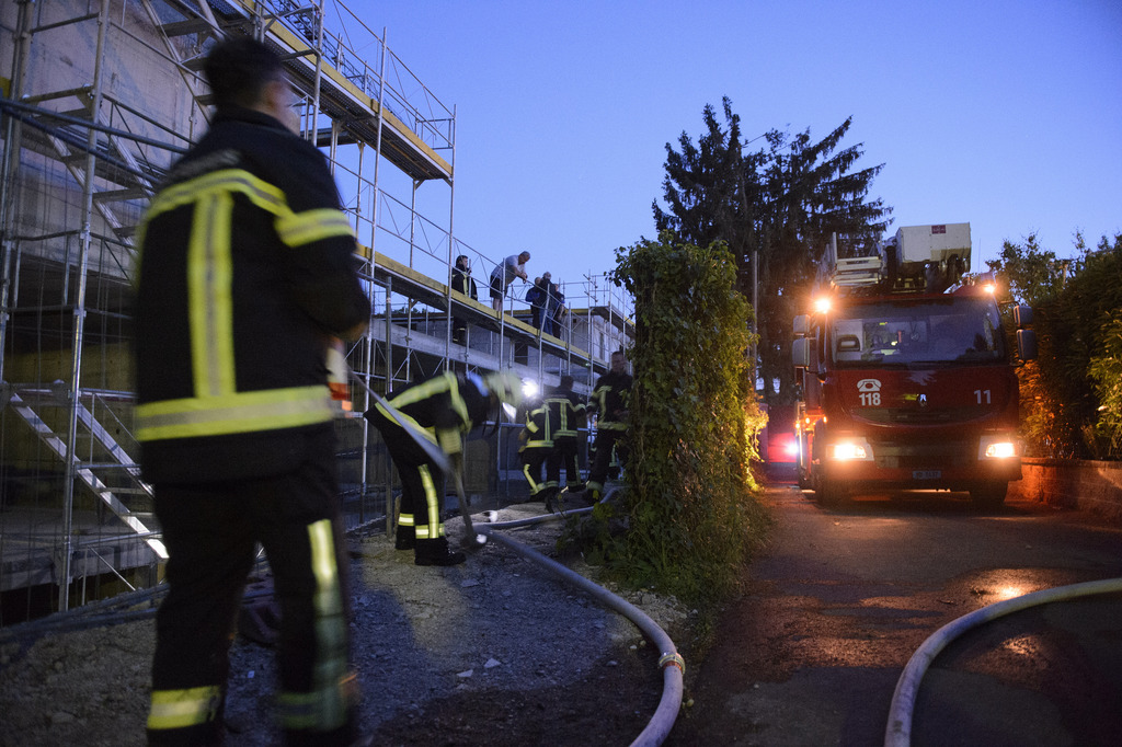 Des pompiers s?affairent sur un incendie sur un chantier ou plusieurs bouteilles de gaz ont explose, ce mercredi 27 mai 2015 a Coppet. (KEYSTONE/Martial Trezzini)
