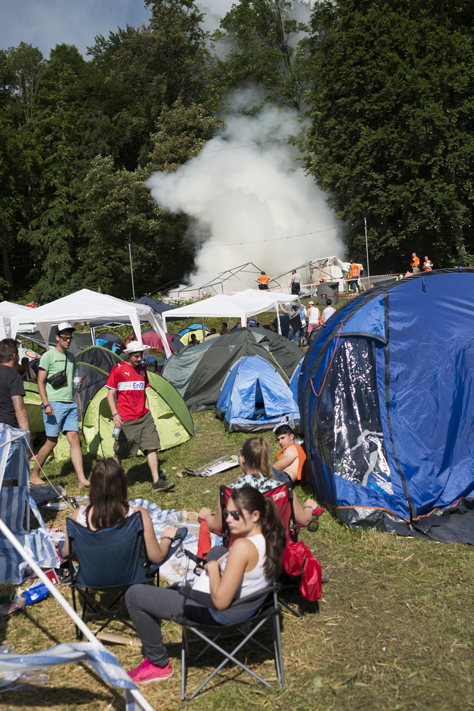 Firemen clear burning tents during the music festival Openair St. Gallen, on Sunday, June 28, 2015, in St. Gallen, Switzerland. The event runs until June 28. (KEYSTONE/Gian Ehrenzeller)