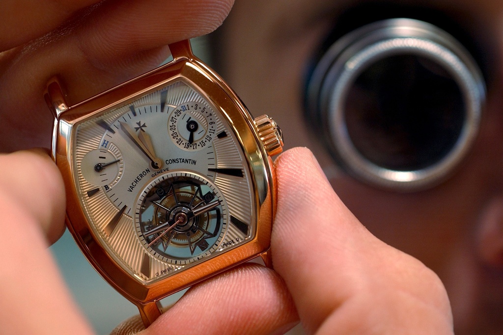 Un horloger de Vacheron-Constantin travaille sur untourbillon en or jaune, dans les ateliers du nouveau siege Vacheron-Constantin de Plan-Les-Ouates GE, photographie le 18 aout 2004.  Vacheron Constantin a investi quelque 35 millions de francs a Plan-les-Ouates (GE) dans une manufacture voulue "lumineuse et transparente" par son patron Claude-Daniel Proellochs. Inauguree mardi, 7 septembre 2004, elle abrite en ses murs de verre et de beton 170 collaborateurs. C'est l'architecte franco-suisse Bernard Tschumi, qui a construit la nouvelle unite de production de Vacheron Constantin, egalement siege international de la marque. Il aura fallu deux ans de programmation et dix-huit mois de travaux seulement pour eriger un batiment de 7000 m sur une parcelle de 30 000 m plantee d'arbres adultes.  (KEYSTONE/Sandro Campardo) === ELECTRONIC IMAGE === 