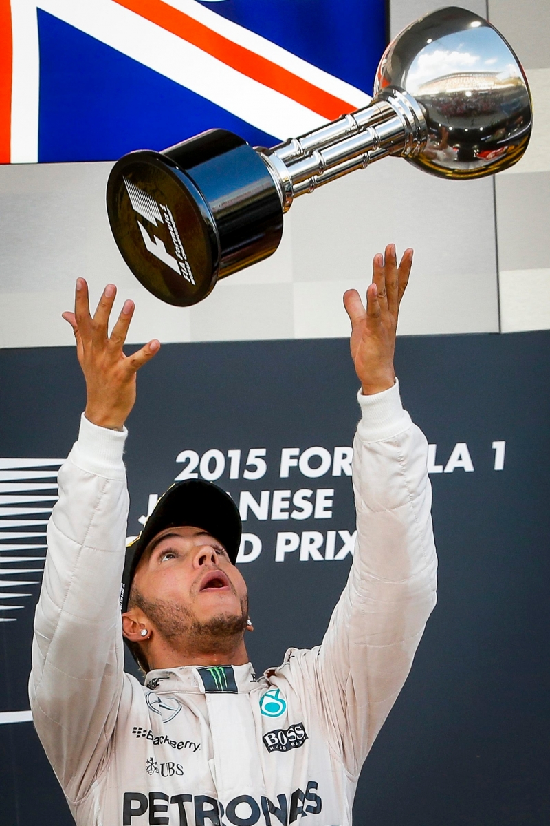 epa04951942 British Formula One driver Lewis Hamilton of Mercedes AMG GP celebrates with his trophy on the podium after winning the Japanese Formula One Grand Prix, at the Suzuka Circuit in Suzuka, central Japan, 27 September 2015.  EPA/DIEGO AZUBEL JAPAN FORMULA ONE GRAND PRIX