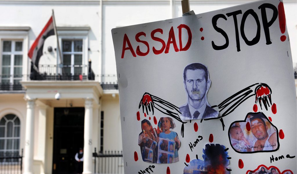 epa03240755 An anti-Syrian president Bashar al-Assad placard is seen outside the Syrian Embassy in London, Britain, 29 May 2012. Britain has expelled the ambassador of Syria from the UK in protest at the alleged massacre by security forces of more than 100 people in Houla, Syria.  EPA/ANDY RAIN