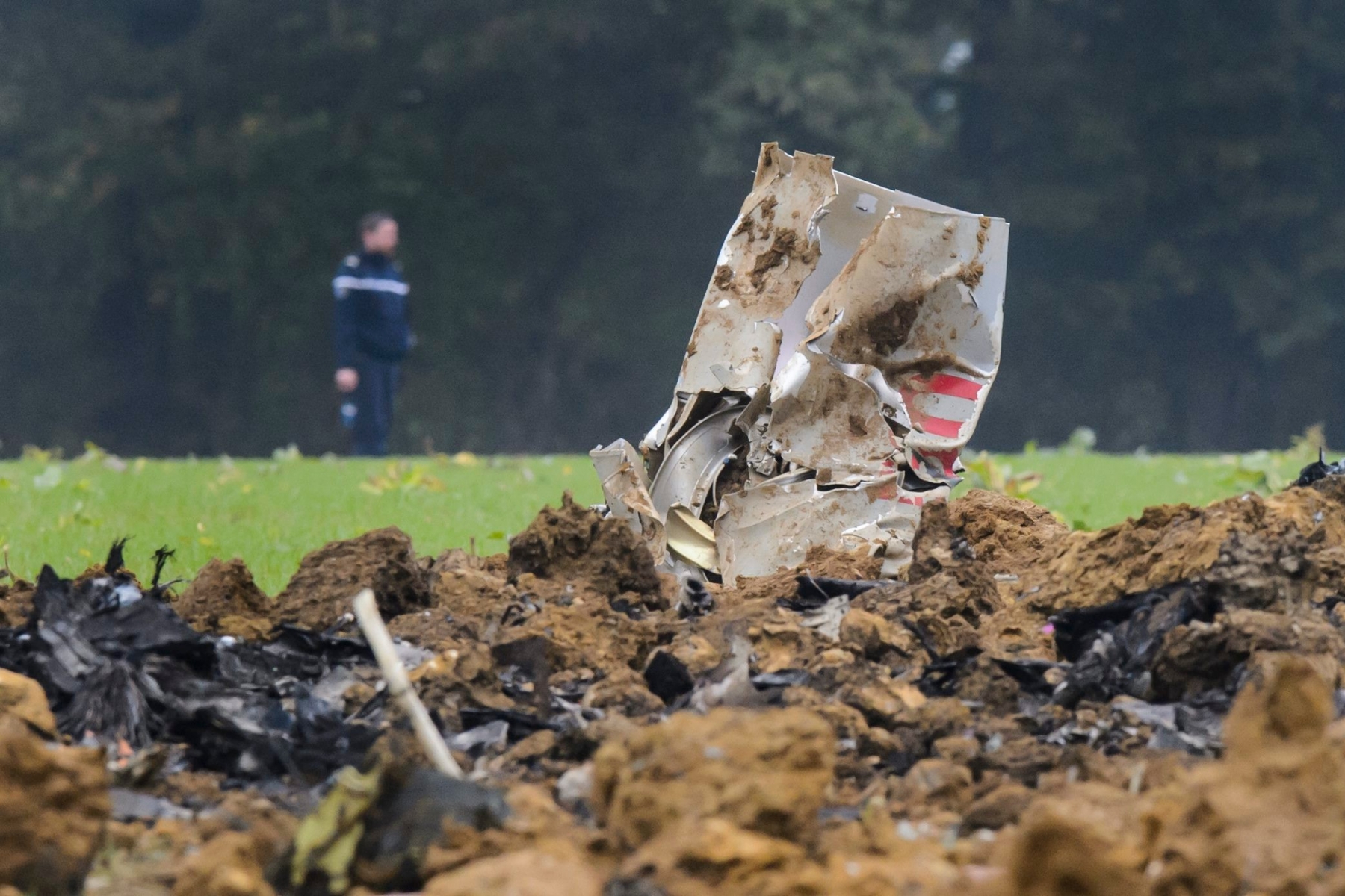 A French Gendarmerie officer walks next to the crash scene with pieces of a wreckage of a Swiss Army F/A-18 jet, in Glamondans, near Besancon, in France, Wednesday, 14 October 2015. An F/A-18 jet fighter belonging to the Swiss Air Force crashed on Wednesday morning during a training exercise in eastern France. The one-seater aircraft crashed into an uninhabited area. The pilot, who ejected to safety, has been injured. (KEYSTONE/Jean-Christophe Bott) FRANCE CRASH F/A-18 JET SWISS ARMY