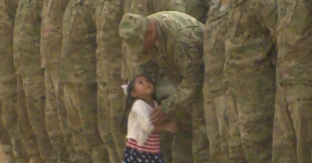 La petite fille a repéré son papa parmi les soldats.