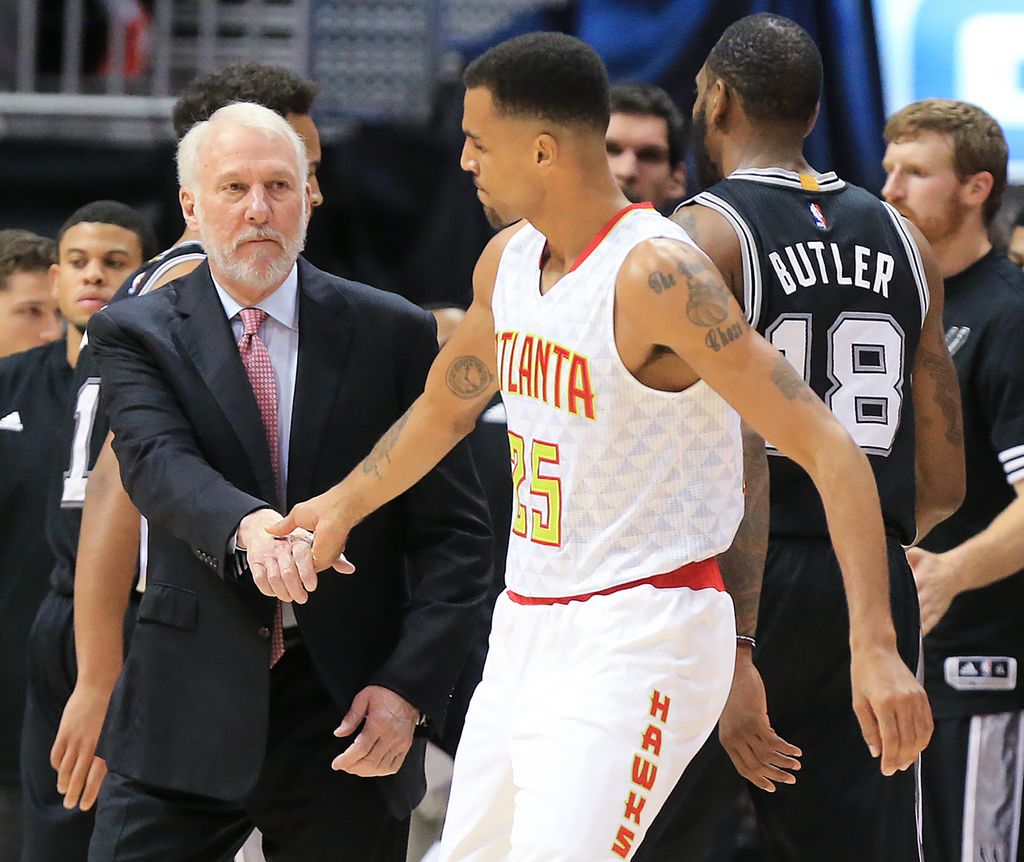 Le coach des San Antonio Spuer Gregg Popovitch salue Thabo Sefolosha sur le terrain d'un match amical.