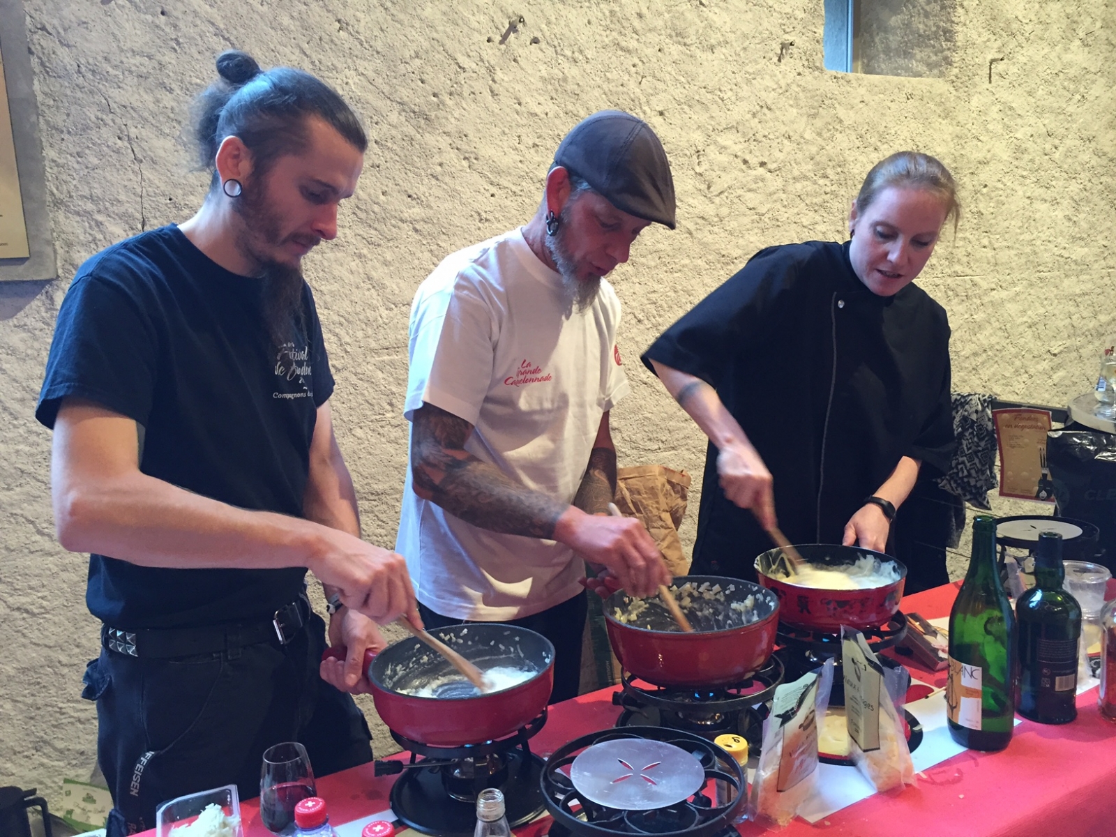 Arnaud, Fred et Jennifer, membres des Compagnons du Caquelon, s'affairent pour préparer les fondues de dégustation.