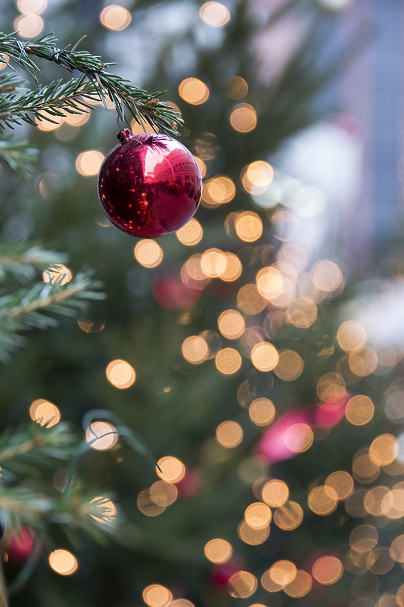 Eine Weihnachtskugel haengt an einem Tannenbaum am Weihnachtsmarkt um den Barfuesserplatz in Basel am Freitag, 19. Dezember 2014. (KEYSTONE/Georgios Kefalas)