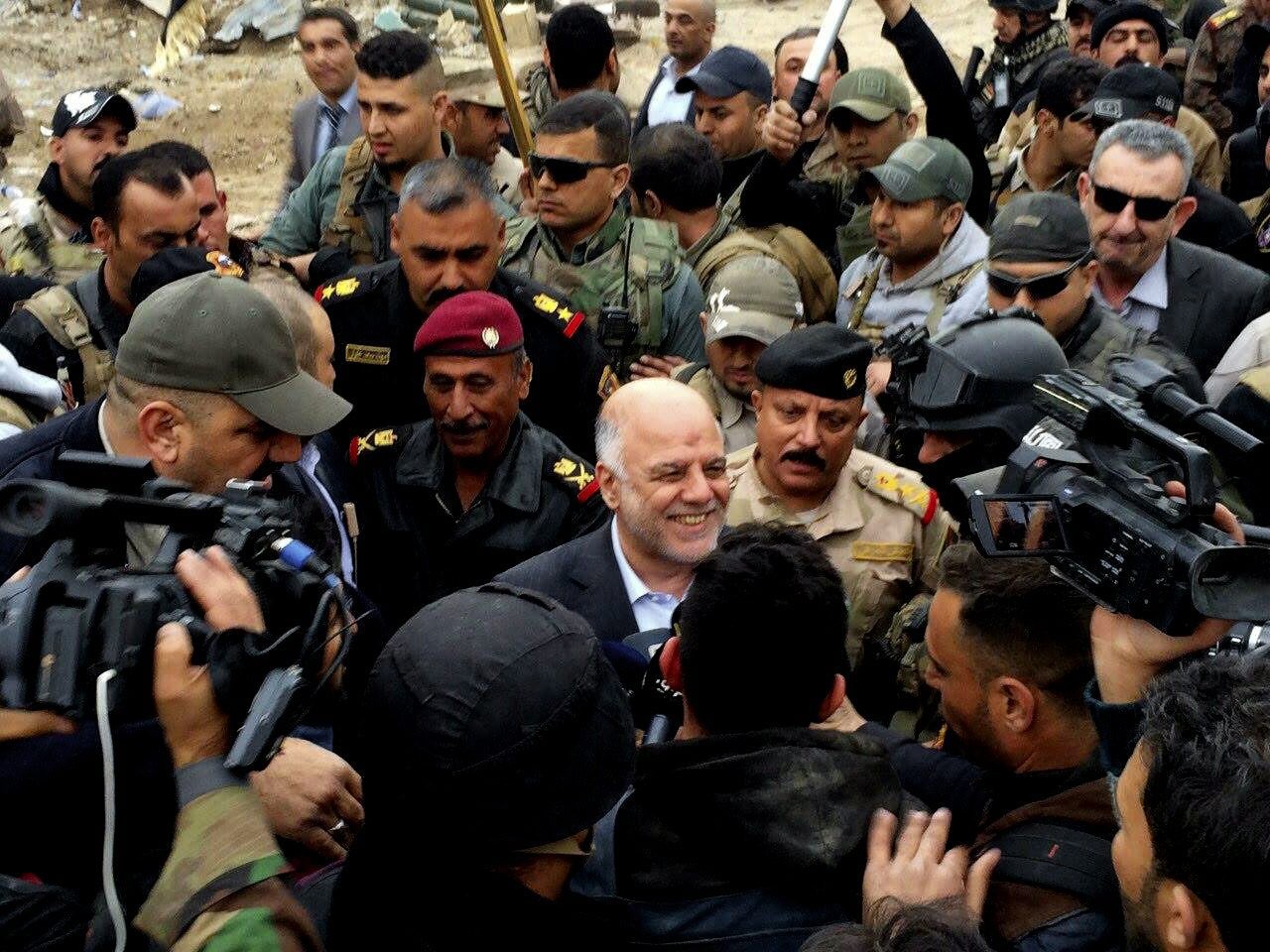 Iraqi Prime Minister Haider al-Abadi, center, smiles as he tours the city of Ramadi after it was retaken by the security forces in Ramadi, 70 miles (115 kilometers) west of Baghdad, Iraq, Tuesday, Dec. 29, 2015. Iraqi military forces on Monday retook a strategic government complex in the city of Ramadi from Islamic State militants who have occupied the city since May. (AP Photo) Mideast Iraq Islamic State