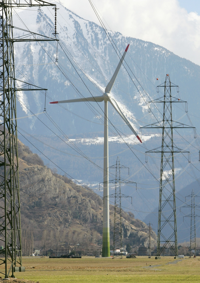 La plus grande eolienne de Suisse, d'une hauteur de mat 100 metres avec des pales culminent a 134 metres du sol et produisant 2 MW de puissance electrique, surgit entre les pylones du reseau electrique a haute-tension, ce jeudi 23 mars 2006 a Collonges (Valais). (KEYSTONE/Salvatore Di Nolfi)