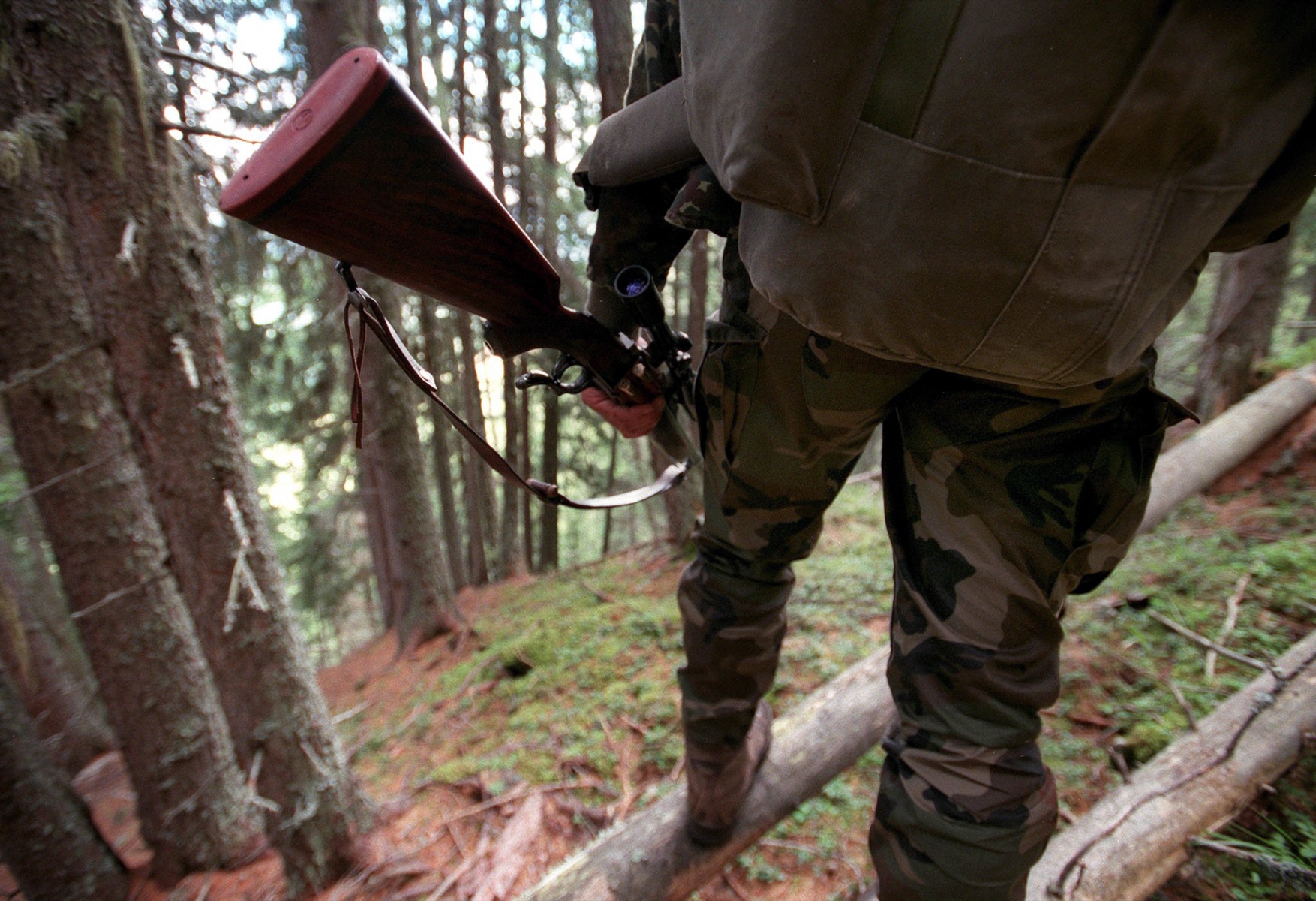 Aux aurores un chasseur cherche sa proie, dans la foret, a Combartseline sur la commune de Nendaz en Valais ce jeudi 20 septembre 2001. La chasse au gros gibier a debute lundi 17 septembre. Cette annee le service de la chasse espere une reduction d'un quart de l'effectif de cerfs. Avec 4000 tetes, le seuil de saturation est atteint et les degats causes aux forets par ces animaux sont importants. Si les chasseurs n'abattent pas un millier de cerfs, des tirs complementaires seront organises. (KEYSTONE/Andree-Noelle Pot) SCHWEIZ JAGD