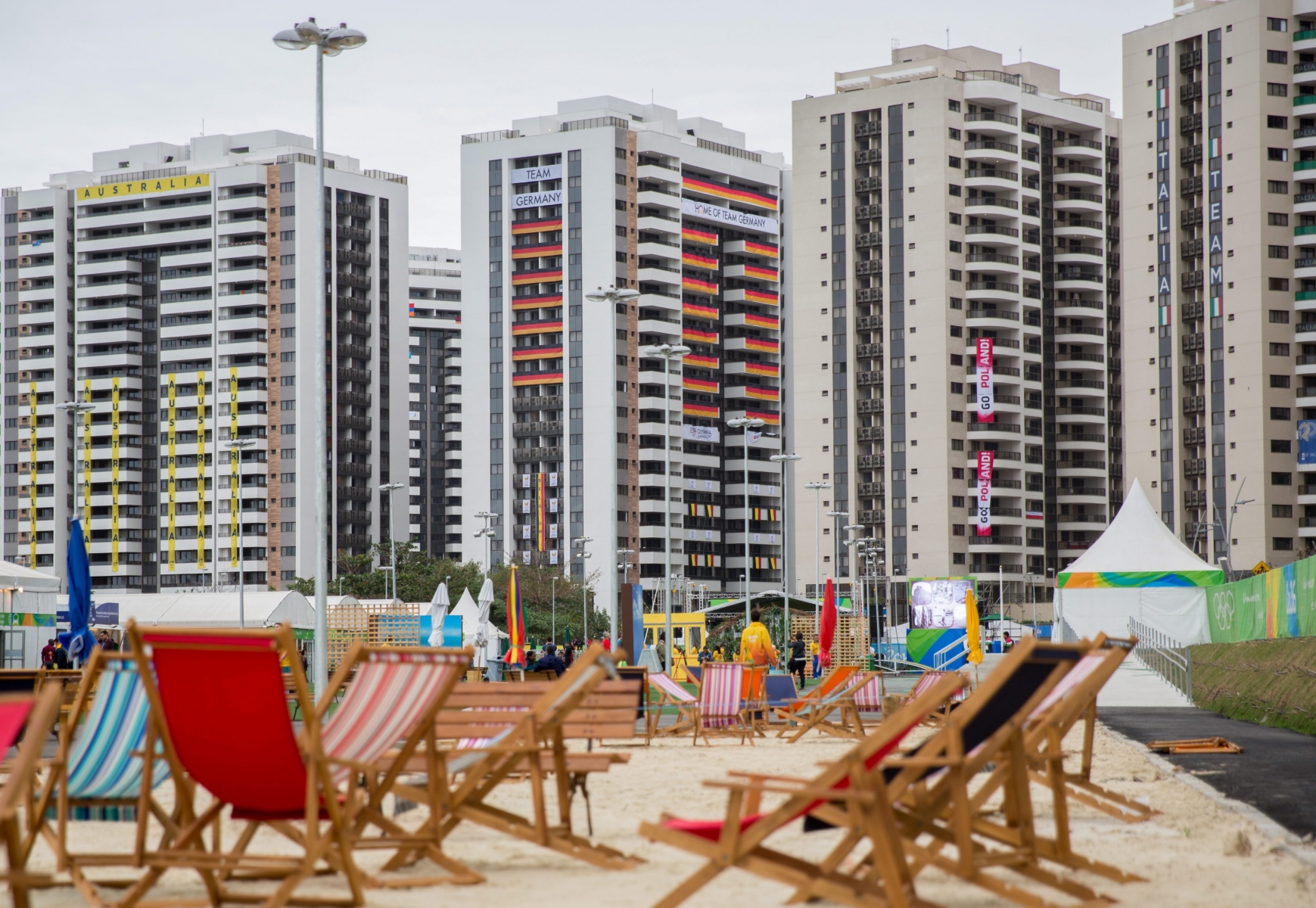 epa05446174 A view of the accommodation building of the delegations of (L-R) Australia, Germany, Poland and Italy from behind a beach area with sun loungers in the Olympic village in Rio de Janeiro,†Brazil, 28 July 2016. The 2016 Olympic Games will take place in Rio de Janeiro from 05 to 21 August 2016.  EPA/Michael Kappeler BRAZIL RIO 2016 OLYMPIC GAMES