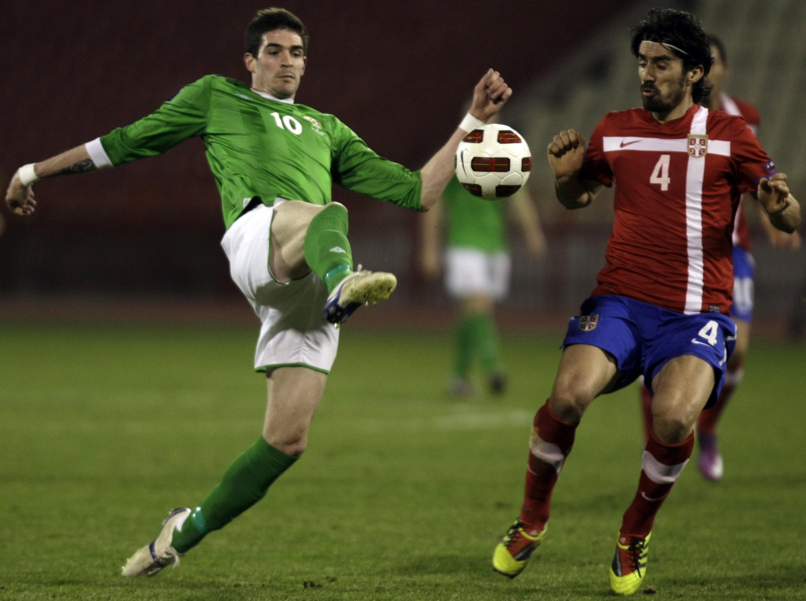 Kyle Lafferty of Northern Ireland, left, touches the ball ahead of Serbia's Milan Bisevac during their Euro 2012 Group C qualifying soccer match in Belgrade, Serbia, Friday, March 25, 2011. (AP Photo/ Marko Drobnjakovic)