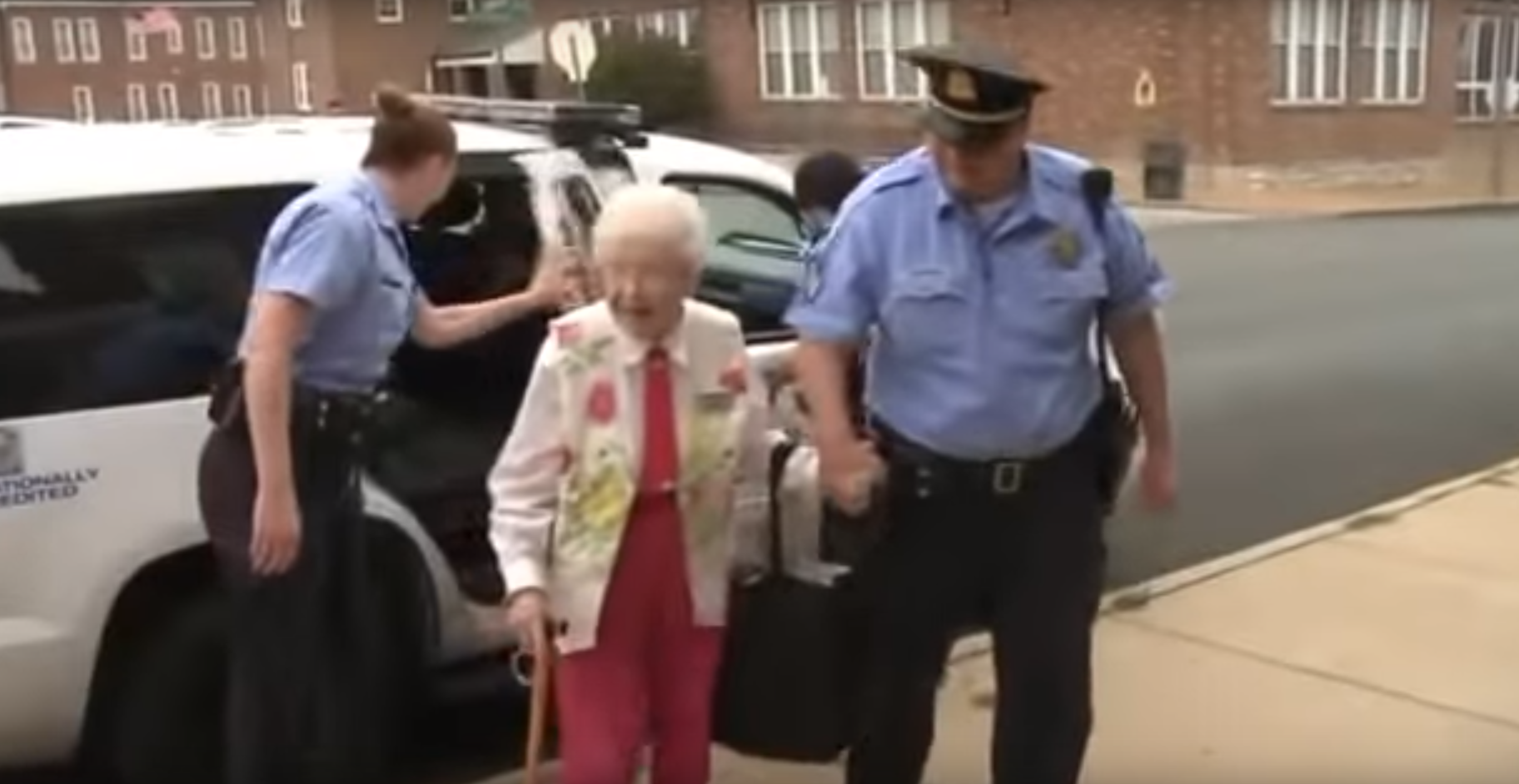 La dame a été escortée par la police menottes au poignet.