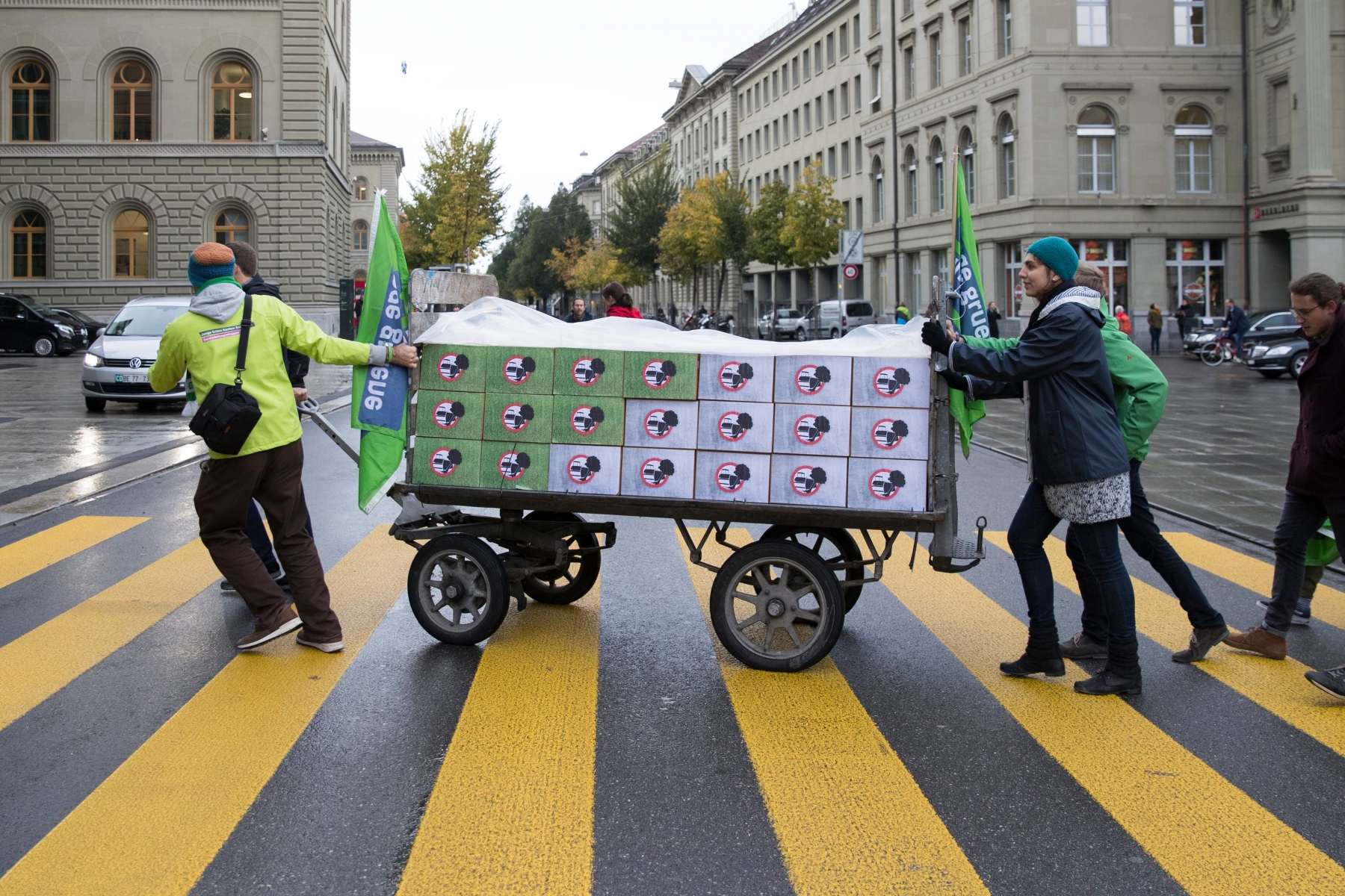 Mitglieder des Initiativkomitees schieben die gesammelten Unterschriften auf einem Wagen ueber die Bundesgasse, bei der Einreichung der Unterschriften fuer die Volksinitiative "Zersiedelung stoppen - fuer eine nachhaltige Siedlungsentwicklung (Zersiedelungsinitiative)", am Freitag, 21. Oktober 2016 in Bern. (KEYSTONE/Peter Klaunzer) SCHWEIZ ZERSIEDELUNGSINITIATIVE