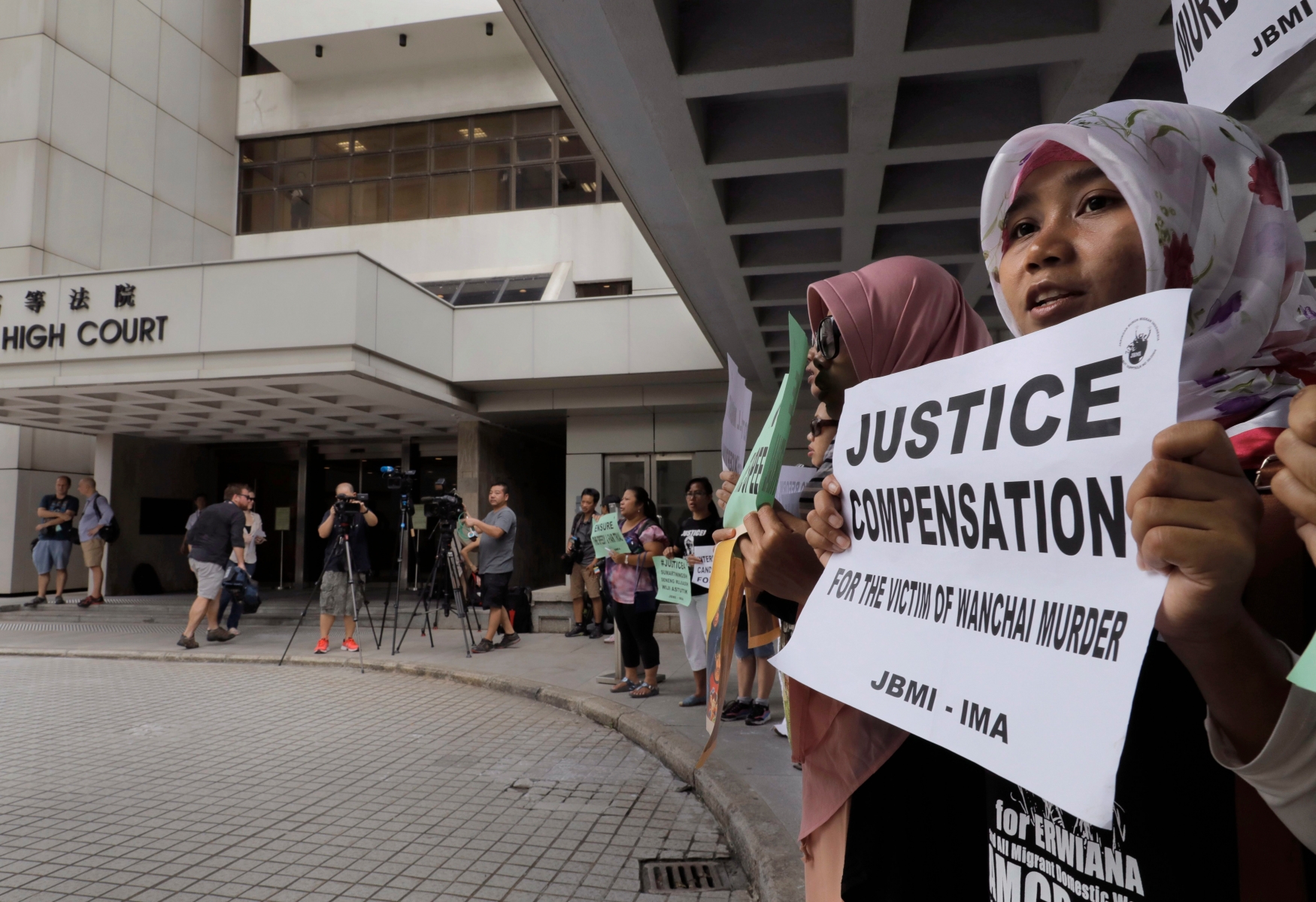 A migrant workers alliance group holds placards to protest the killings of two Indonesian women in 2014 outside the High Court in Hong Kong, Monday, Oct. 24, 2016. British banker Rurik Jutting accused of the grisly 2014 killings pleaded not guilty when he went on trial Monday, in a case expected to highlight the Asian financial hub's inequality and privileged lifestyle of its wealthy expat elite. (AP Photo/Vincent Yu) Hong Kong British Banker Murder Trial