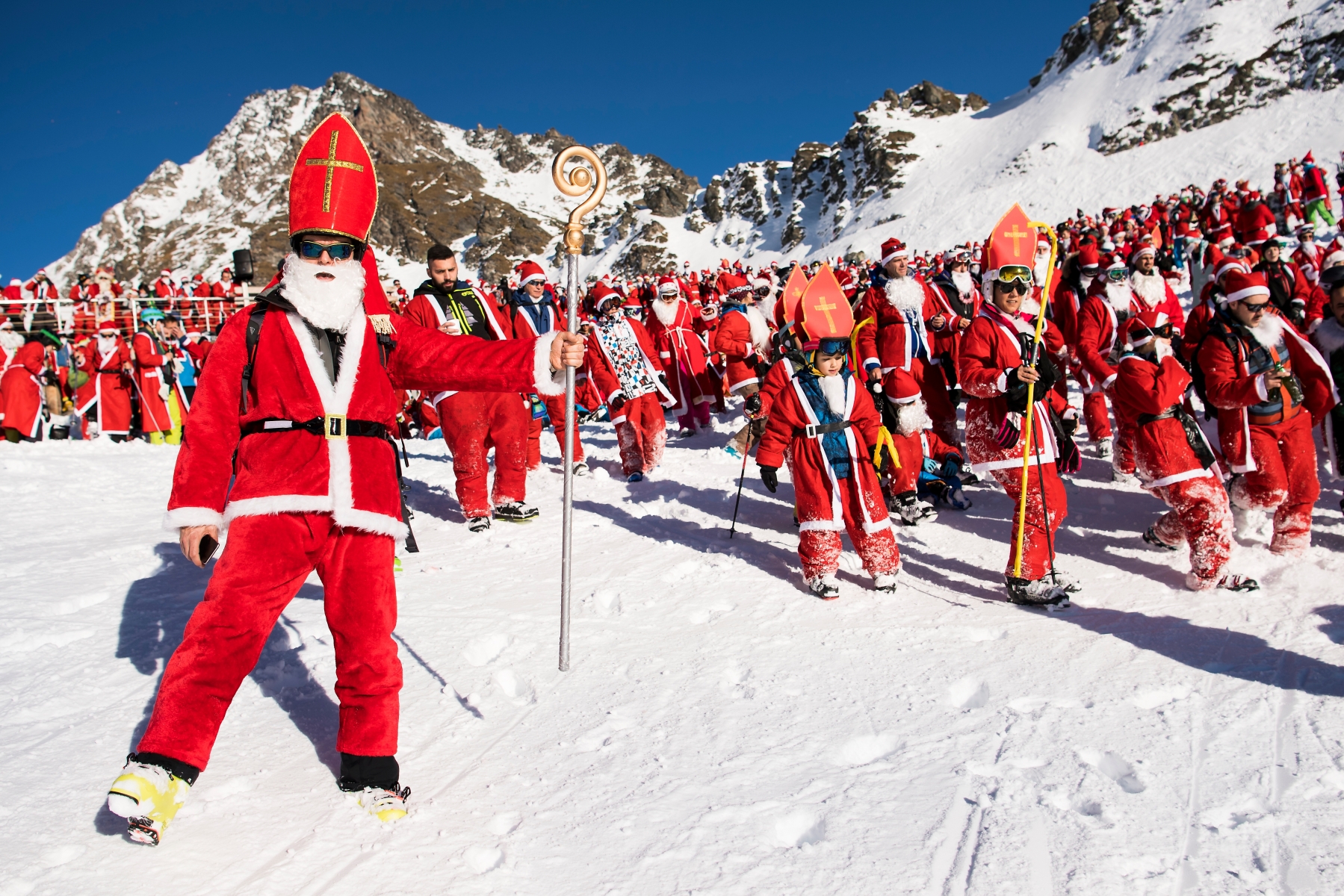 People dressed as Santa Claus, pose for a group picture on the slope during a promotional event on the opening weekend in the alpine ski resort in Verbier, Saturday, December 3, 2016. Around 1200 skiers dressed as Santa Claus were granted free access to the ski resort to celebrates the ski season's opening. (KEYSTONE/Jean-Christophe Bott) SWITZERLAND SKI SANTA CLAUS