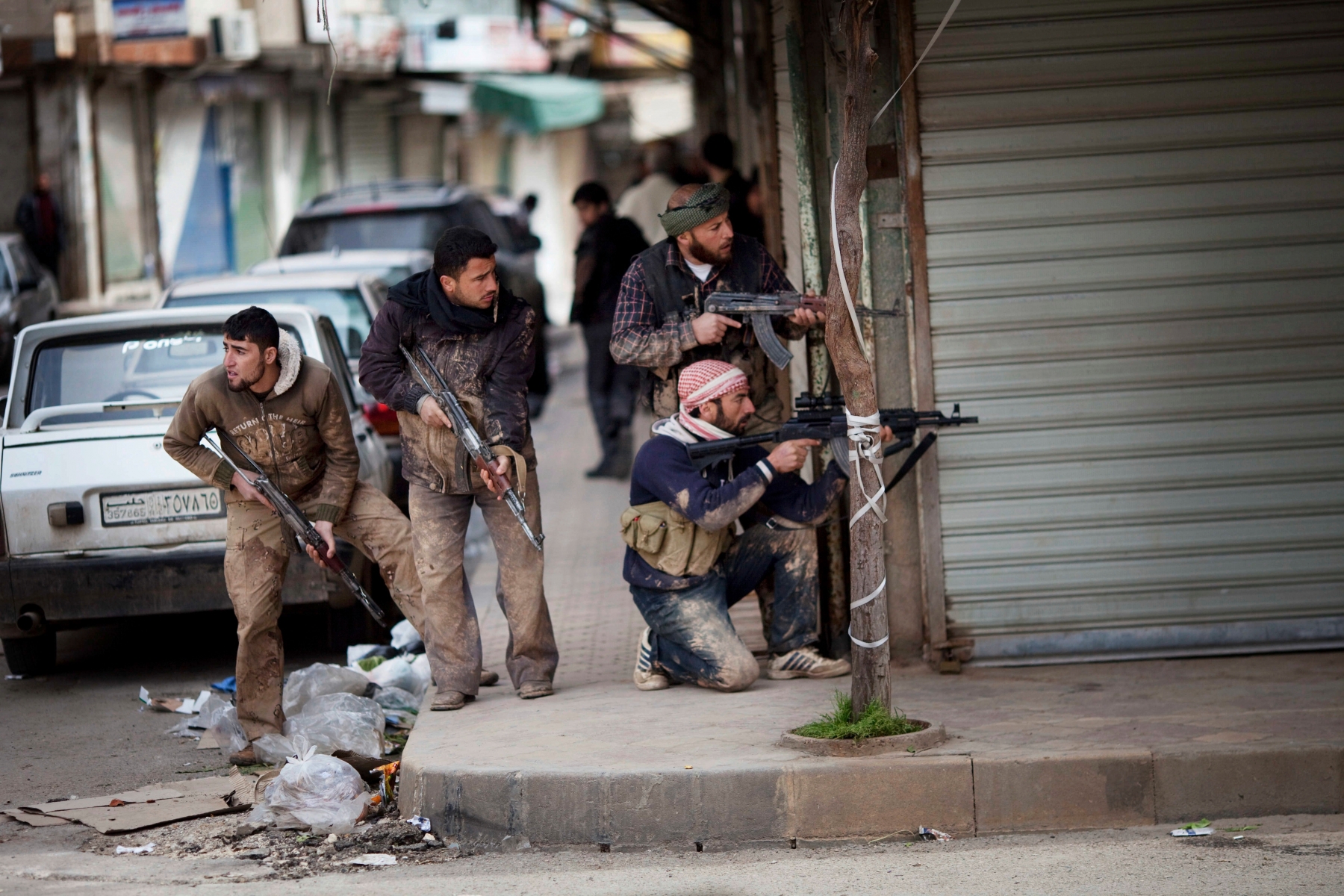 In this Sunday, March 11, 2012 photo, Syrian rebels take position during clashes with government forces in Idlib, north Syria. Syrian activists said Monday that pro-government gunmen have killed several people including children in a rebel stronghold recaptured by the government in the embattled central city of Homs. (AP Photo/Rodrigo Abd) Mideast Syria