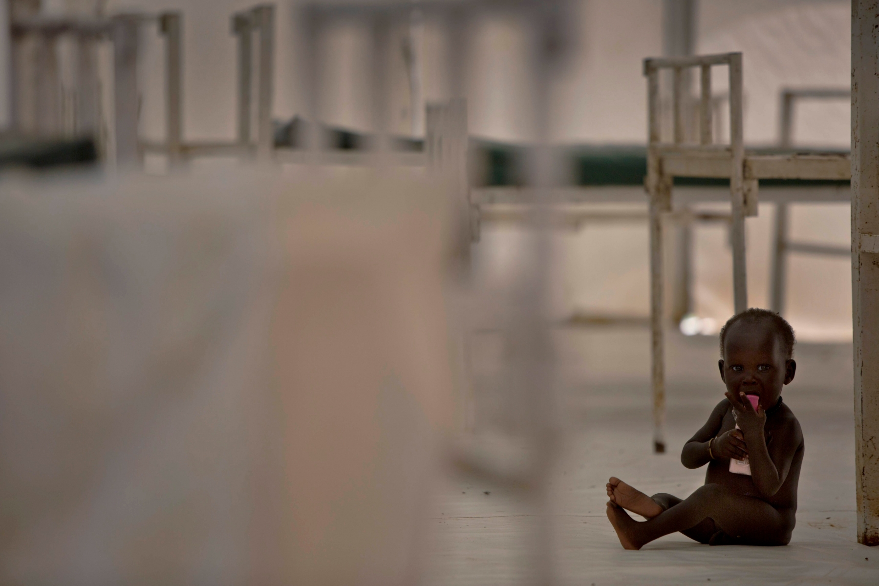In this photo taken Sunday, Oct. 23, 2016 and released by UNICEF, a young child sits on the floor in the therapeutic feeding unit of the Medecins Sans Frontieres (Doctors Without Borders) hospital in the UN Protection of Civilians Camp in Bentiu, South Sudan. Famine has been declared Monday, Feb. 20, 2017 in two counties of South Sudan, according to an announcement by the South Sudan government and three U.N. agencies, which says the calamity is the result of prolonged civil war and an entrenched economic crisis that has devastated the war-torn East African nation. (Kate Holt/UNICEF via AP) South Sudan Famine