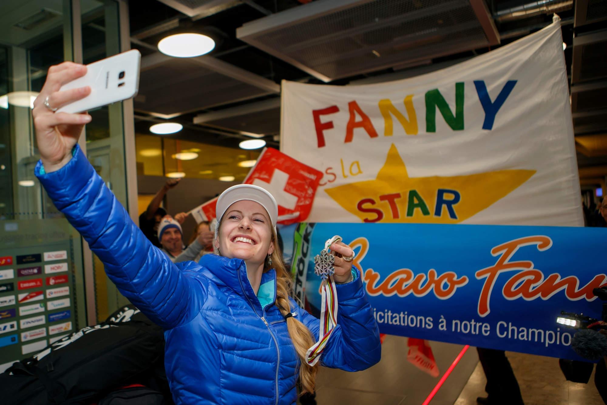 Switzerland's Fanny Smith, ski cross silver medalist at the World Championships, makes a selfie with her supporters, at the Geneva airport, in Geneva, Switzerland, Sunday, March 19, 2017. Switzerland's skier Fanny Smith won the silver medal of the Women's Ski Cross final at the FIS Freestyle Ski and Snowboard World Championships 2017 in Sierra Nevada, Spain. (KEYSTONE/Salvatore Di Nolfi) SWITZERLAND FIS WC FREESTYLE SKI CROSS