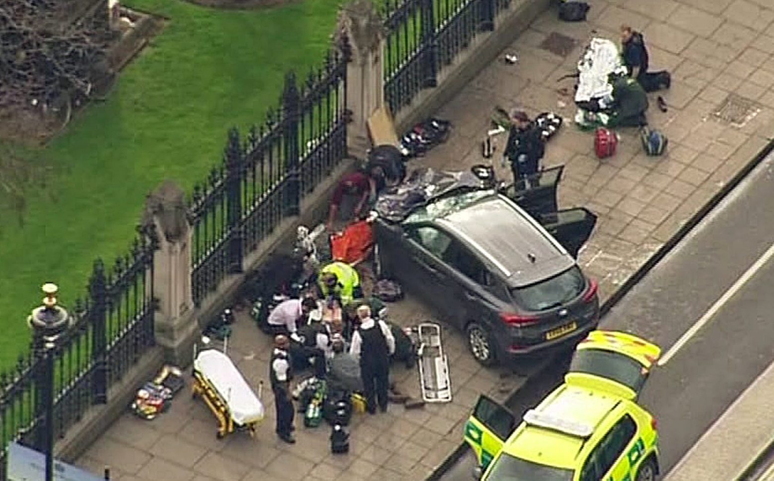 In this image taken from video police officers gather around a car adjacent to Houses of Parliament in London, Wednesday, March 23, 2017 after the House of Commons sitting was suspended as witnesses reported sounds like gunfire outside. The leader of Britain's House of Commons says a man has been shot by police at Parliament. David Liddington also said there were "reports of further violent incidents in the vicinity." (ITN via AP) Britain Parliament Incident