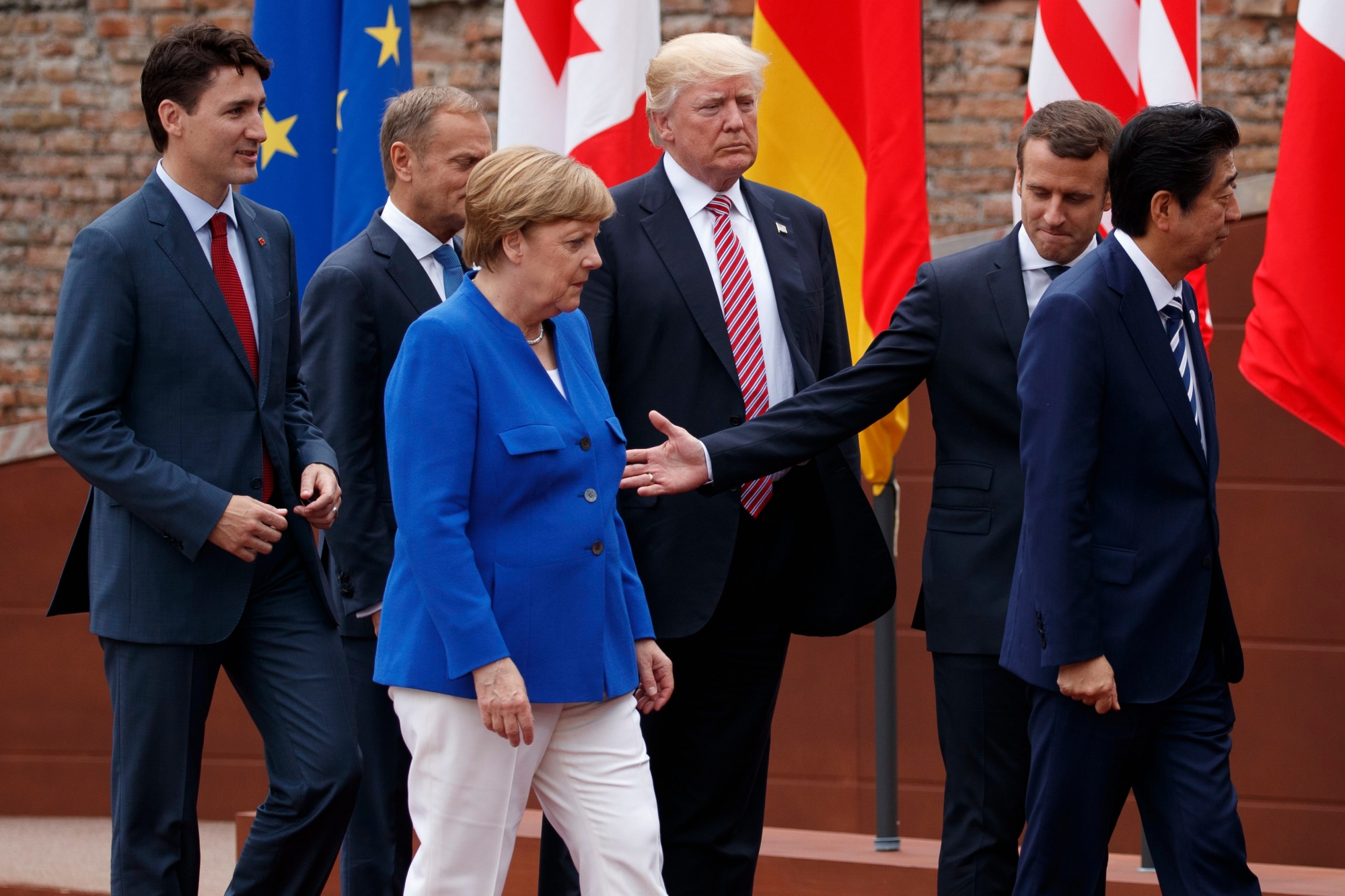 G7 leaders, from left, Canadian Prime Minister Justin Trudeau, President of the European Commission Jean-Claude Junker, German Chancellor Angela Merkel, President Donald Trump, French President Emmanuel Macron, and Japanese Prime Minister Shinzo Abe walk off after a family photo at the Ancient Greek Theater of Taormina, Friday, May 26, 2017, in Taormina, Italy. (AP Photo/Evan Vucci) TRUMP US G7