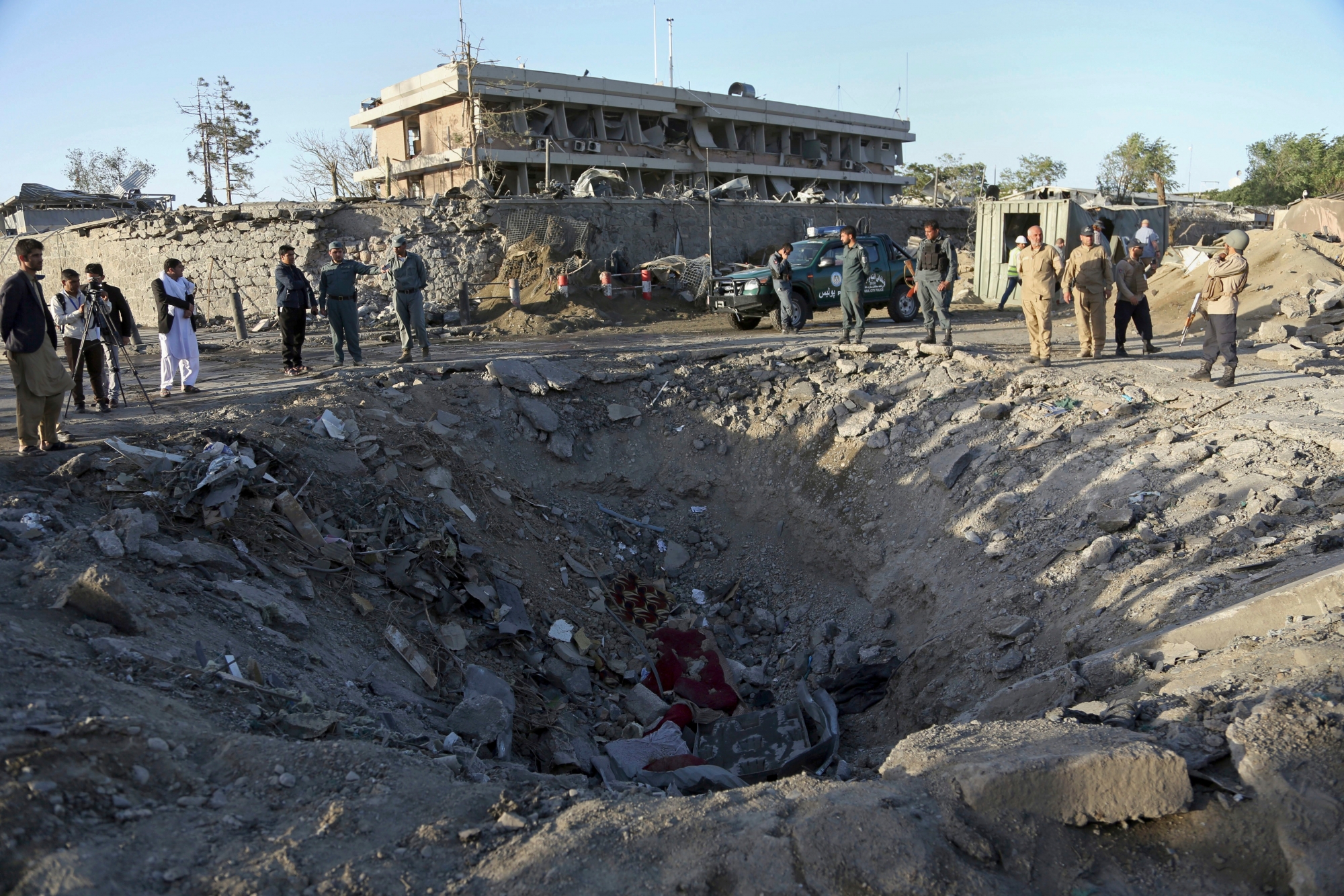 Security forces stand next to a crater created by massive explosion in front of the German Embassy in Kabul, Afghanistan, Wednesday, May 31, 2017. The suicide truck bomb hit a highly secure diplomatic area of Kabul killing scores of people and wounding hundreds more. (AP Photo/Rahmat Gul) Afghanistan