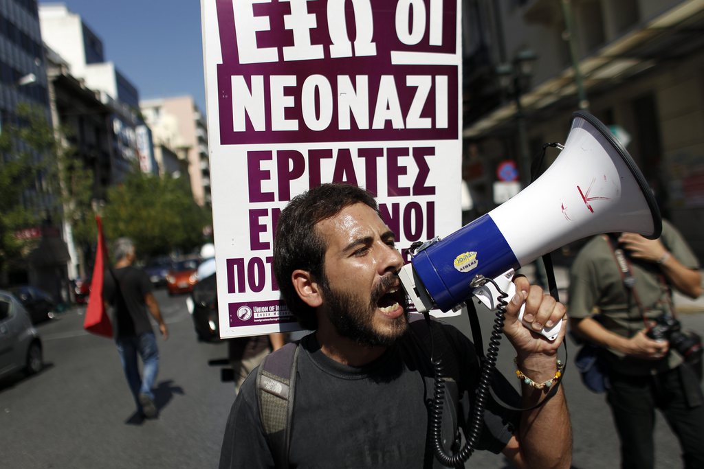 A protester shouts slogans  during a protest against racist attacks and the raise  of the Golden Dawn extreme far-right party, at the port city of Pireaus near Athens on Saturday Sept. 22 2012. Golden Dawn, which political opponents brand as being neo-Nazi, has soared in popularity as Greece sinks deeper into a debt-fueled morass. The party won nearly 7 per cent of the vote in June's election and 18 seats in the country's 300-member parliament. (AP Photo/Kostas Tsironis)