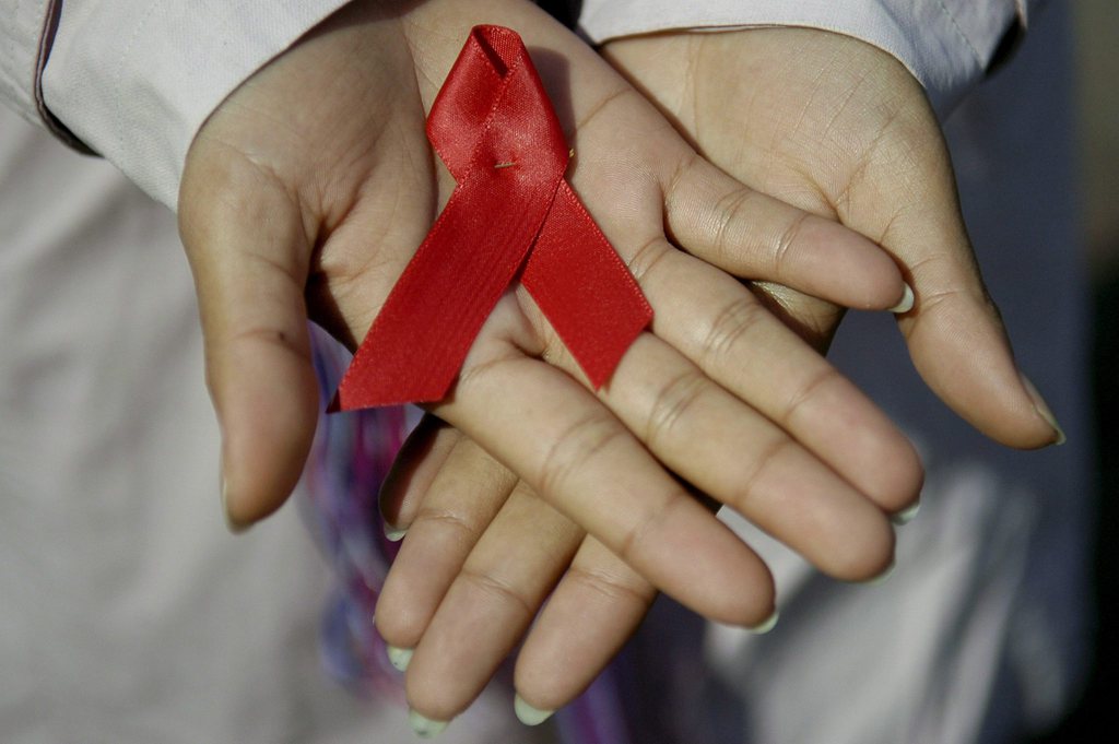 A Guatemalan woman shows a red ribbon in support of the people who suffer AIDS, Thursday, 30 November 2006, in Guatemala, a day before the commemoration of the World Aids Day. According to the last UNAIDS report and the World Health Organization the HIV epidemic is starting to drop down, despite the 4.3 new million cases reported in 2006, which adds to 39.5 million the number of people infected with the virus in the world. The same report indicates that 140.000 of the new cases are from Latin America. Guatemala represents a 1 percent of that figure. Prostitution is one of the main risk factors for the transmission of the disease, unprotected sex between men accounts for 12 percent of reported AIDS cases in Guatemala.  (KEYSTONE/EPA/Ulises Rodriguez)