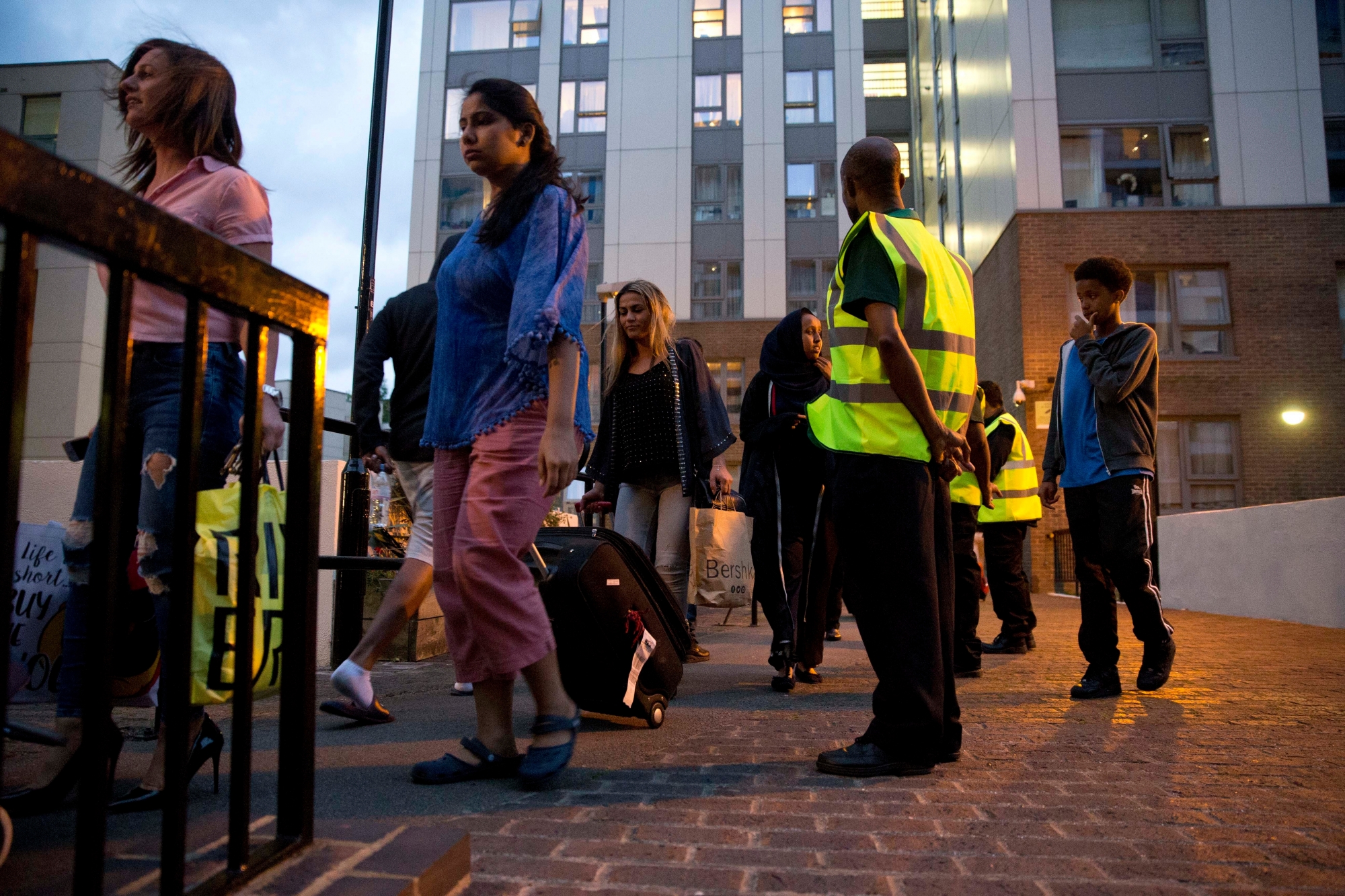 Residents are evacuated from the Taplow residential tower block on the Chalcots Estate, in the borough of Camden, north London, Friday, June 23, 2017. A local London council has decided to evacuate some 800 households in apartment buildings it owns because of safety concerns following the devastating fire that killed 79 people in a west London high-rise. (AP Photo/Alastair Grant) Britain London Fire