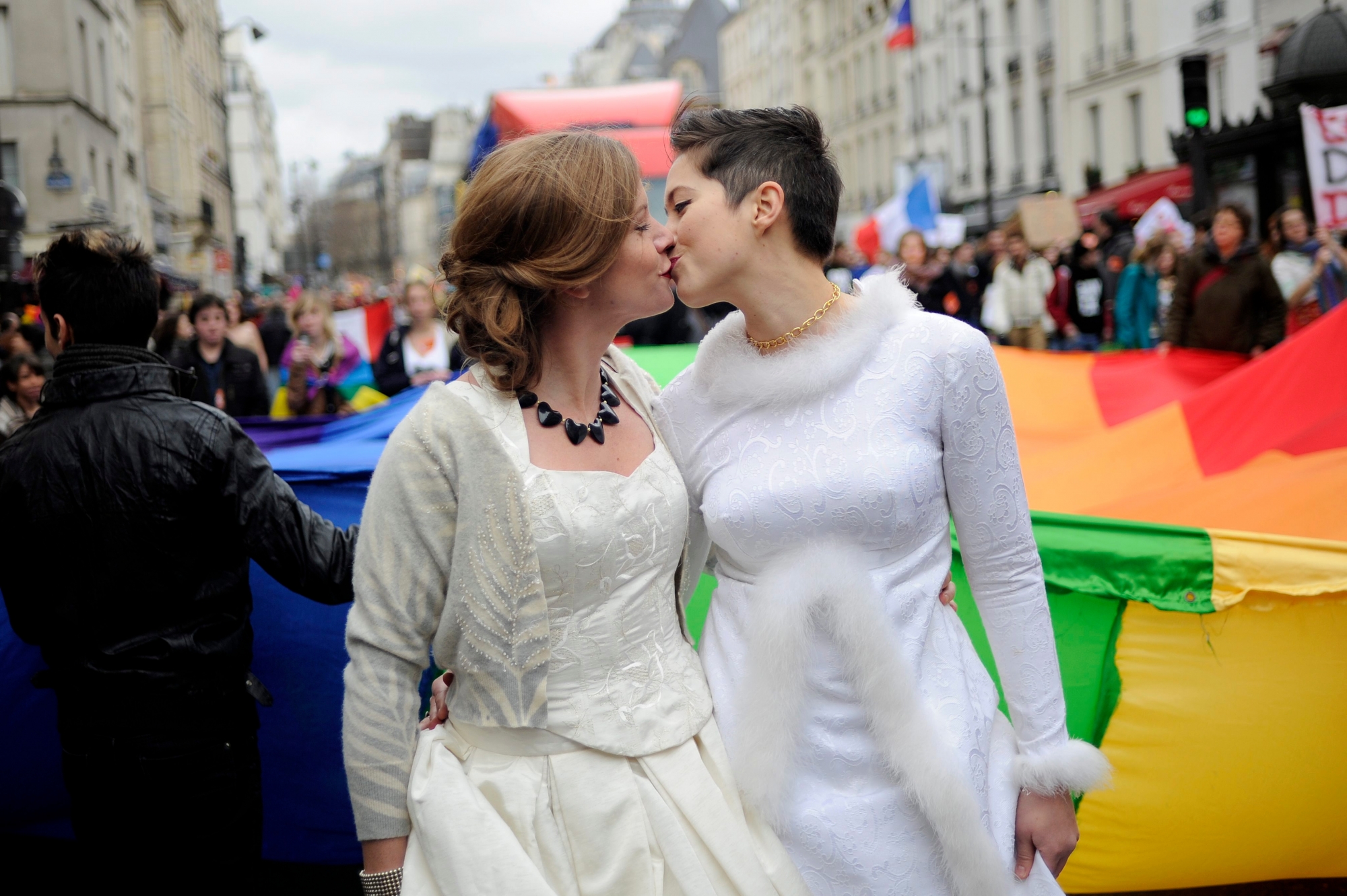 epa03511242 A female couple share a kiss during a demonstration in favour of legalizing gay marriage in Paris, France, 16 December 2012. According to media reports, tens of thousands of people demonstrated 16 December in France in favour of gay marriage, a week after more than 100,000 took to the streets to oppose government moves in that direction.  EPA/YOAN VALAT FRANCE PROTEST GAY MARRIAGE