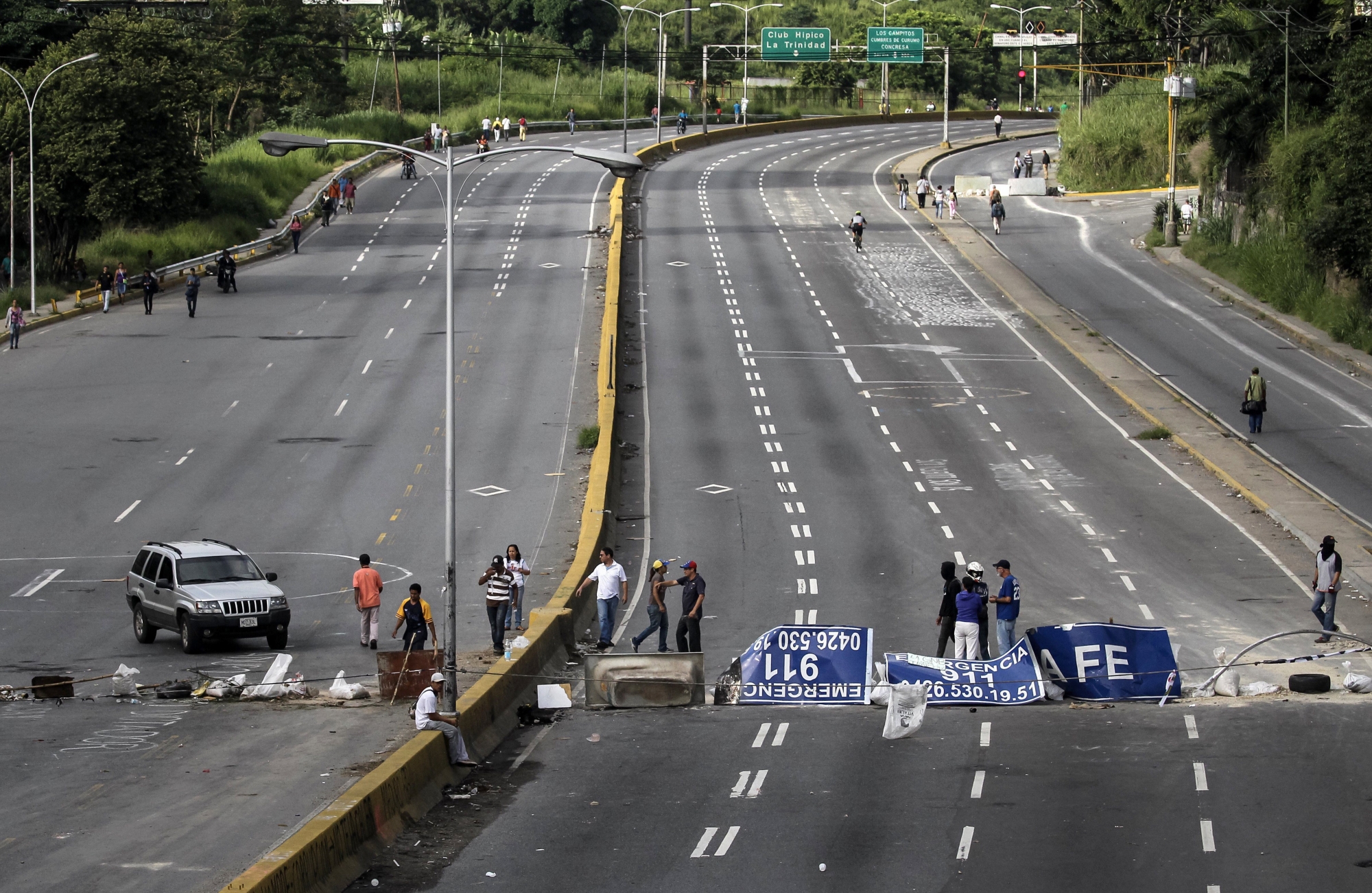 epa06112813 Protesters stand at a makeshift road block on the motorway during the second and last day of the 48-hour general strike convened by the opposition against the Constituent Assembly in Caracas, Venezuela, 27 July 2017. Numerous shops stayed closed during the protest by Venezuelans demanding the resignation of President Nicolas Maduro.  EPA/Miguel Gutiérrez VENEZUELA CRISIS STRIKE