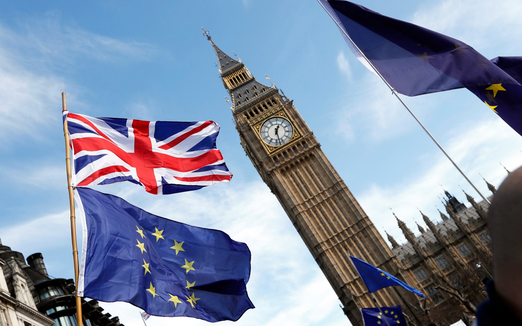 Anti Brexit campaigners carry flags as they march past Big Ben at Britain's parliament in London, Saturday March 25, 2017. Britain's Prime Minister Theresa May is expected to start the process of leaving the European Union on Wednesday March 29. (AP Photo/Kirsty Wigglesworth) Britain Brexit