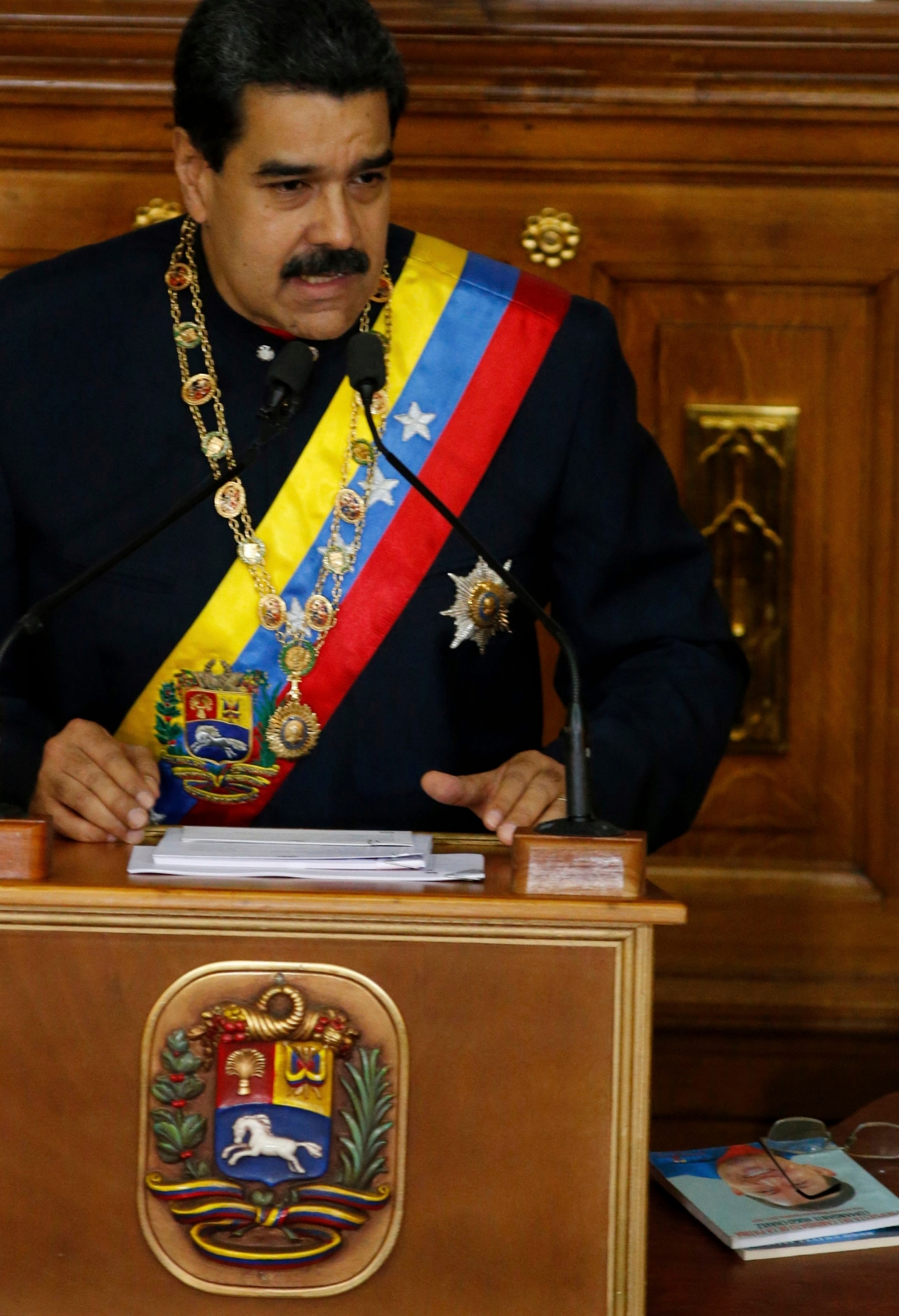 Venezuela's President Nicolas Maduro addresses Constitutional Assembly members at the National Assembly building in Caracas, Venezuela, Thursday, Aug. 10, 2017, as a book at his right shows the face of his late predecessor Hugo Chavez, which outlines Chavez's project coined "Plan de Patria," or "Plan Homeland." Maduro pushed for the creation of the constitutional assembly to rewrite the constitution.  (AP Photo/Ariana Cubillos) Venezuela Political Crisis