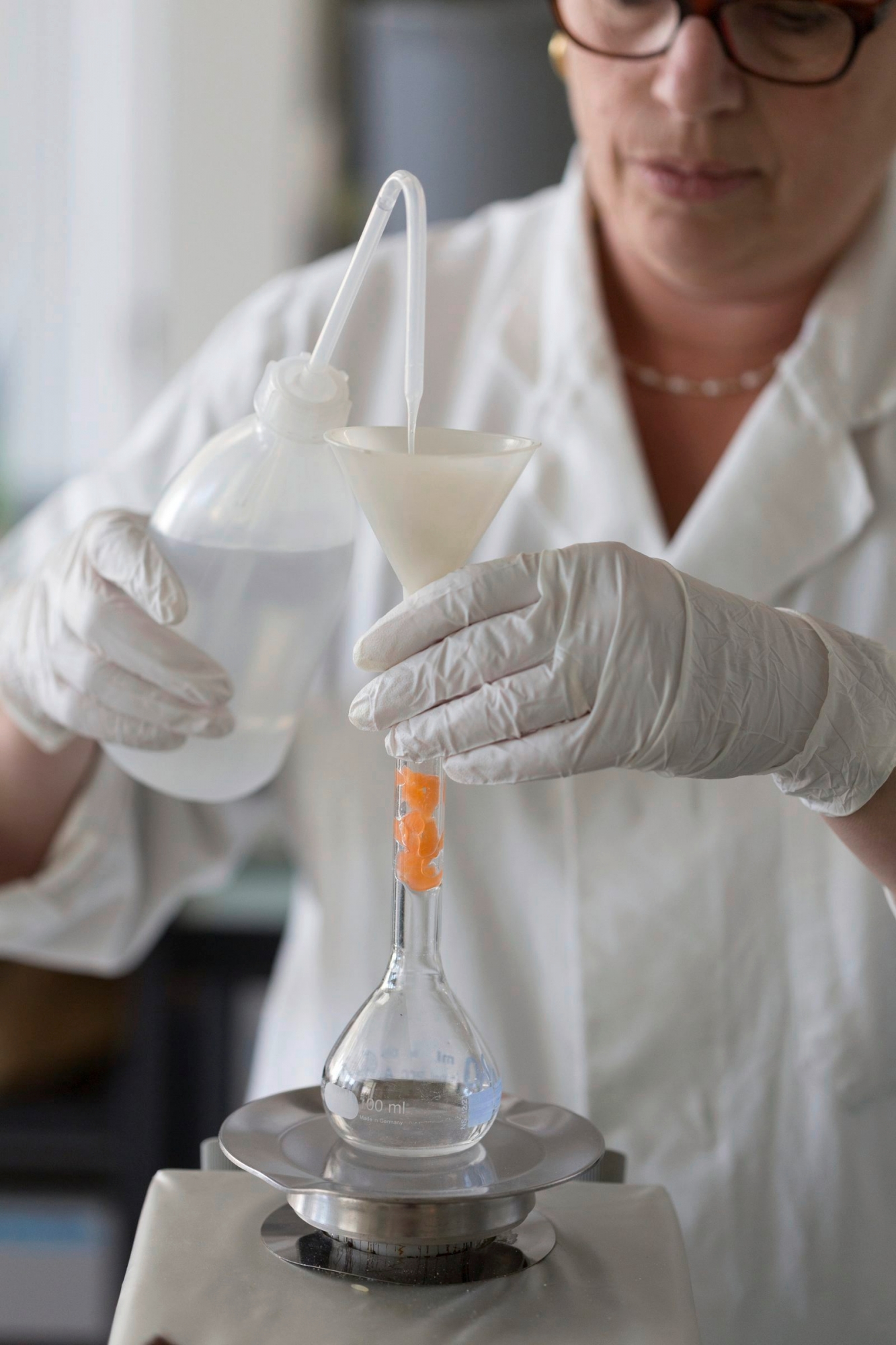 WIR STELLEN IHNEN HEUTE, DONNERSTAG, 4. FEBRUAR 2016, FOLGENDES BILDMATERIAL ZUR ARBEIT DES SWISS VITAMIN INSTITUTES ZUR VERFUEGUNG --- An employee transfers the fluid to be examined with a spray bottle into a volumetric flask and afterwards converts it into an analysable form of the vitamin to be evaluated by use of hydrolysis, pictured at the Swiss Vitamin Institute in Lausanne, canton of Vaud, Switzerland, on September 24, 2015. The Swiss Vitamin Institute, which was founded in 1931, analyzes vitamins in food, pharmaceuticals, cosmetics and biological samples for medical diagnostics of vitamins. (KEYSTONE/Gaetan Bally)
 SCHWEIZ LAUSANNE SWISS VITAMIN INSTITUTE