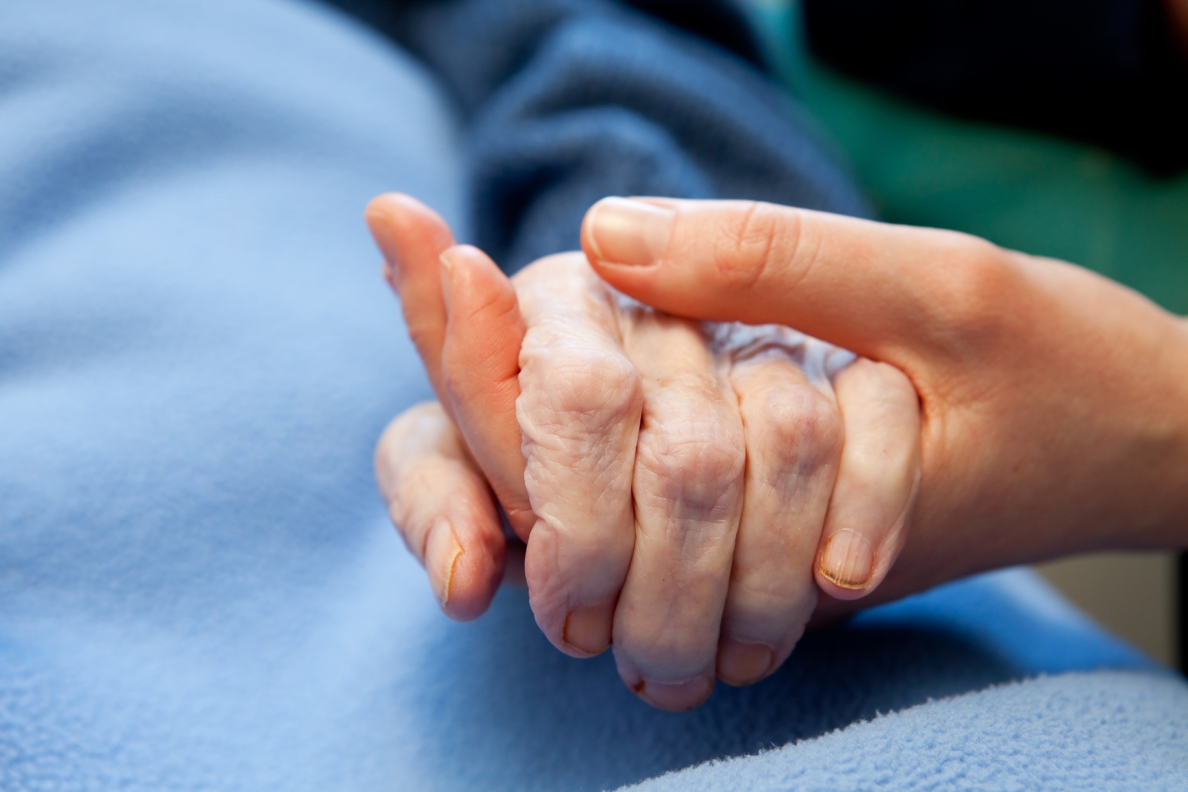 A young hand touches and holds an old wrinkled handsoins Old Hand Care Elderly