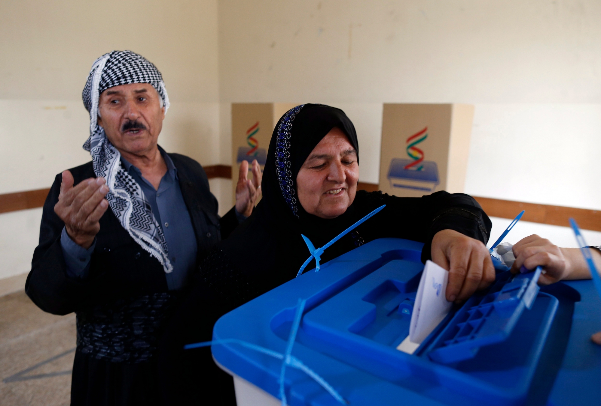 epa06225364 An Iraqi Kurd woman picks up ballot paper before casting her vote at a polling station during Kurdistan independence referendum in Erbil, Kurdistan region in northern Iraq, 25 September 2017. The Kurdistan region is an autonomous region in northern Iraq since 1991, with an estimated population of 5.3 million people. The region share borders with Turkey, Iran, and Syria, all of which have large Kurdish minorities. On 25 September the Kurdistan region holds a referendum for independence and the creation of the state of Kurdistan amidst divided international support.  EPA/MOHAMED MESSARA IRAQ KURDISTAN REFERENDUM