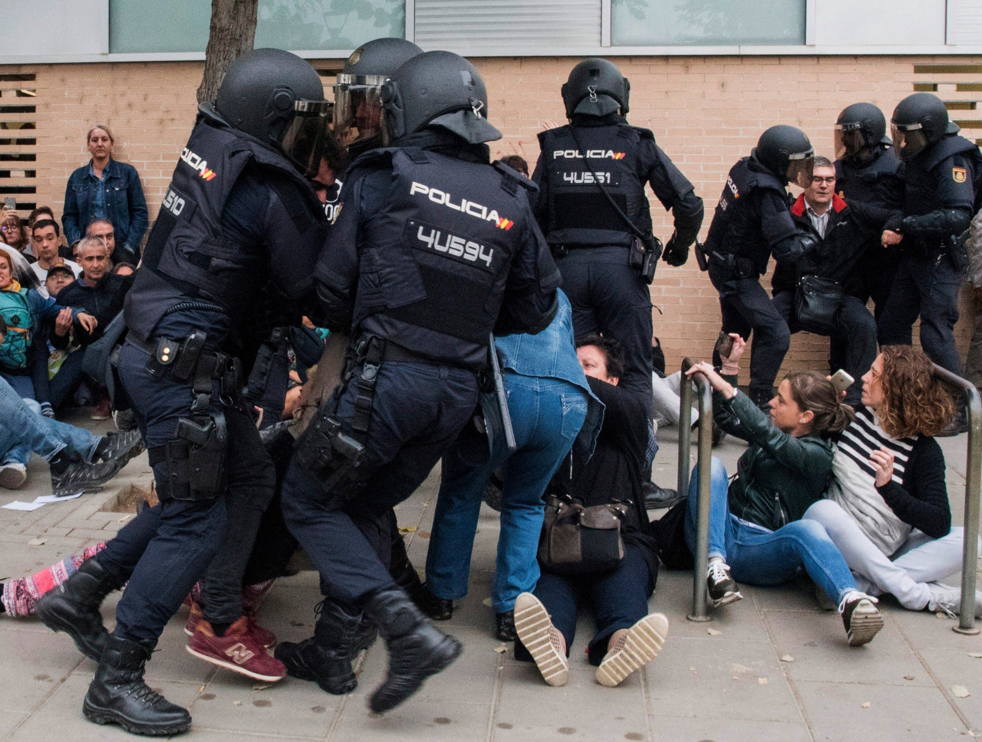 epa06237424 Catalan people clash with police outside at a polling center set at a health clinic clash with Spanish National Police officers after police forces seized ballot boxes during the '1-O Referendum' in Cappont, Lleida, Catalonia, northeastern Spain, on 01 October 2017. National Police officers and Civil guards have been deployed to seize voting material and to prevent the people from entering to the polling centers and vote in the Catalan independence referendum, that has been banned by the Spanish Constitutional Court, what has provocked clashes between pro-independence people and the police forces in some polling centers.  EPA/Adria Ropero SPAIN CATALONIA REFERENDUM