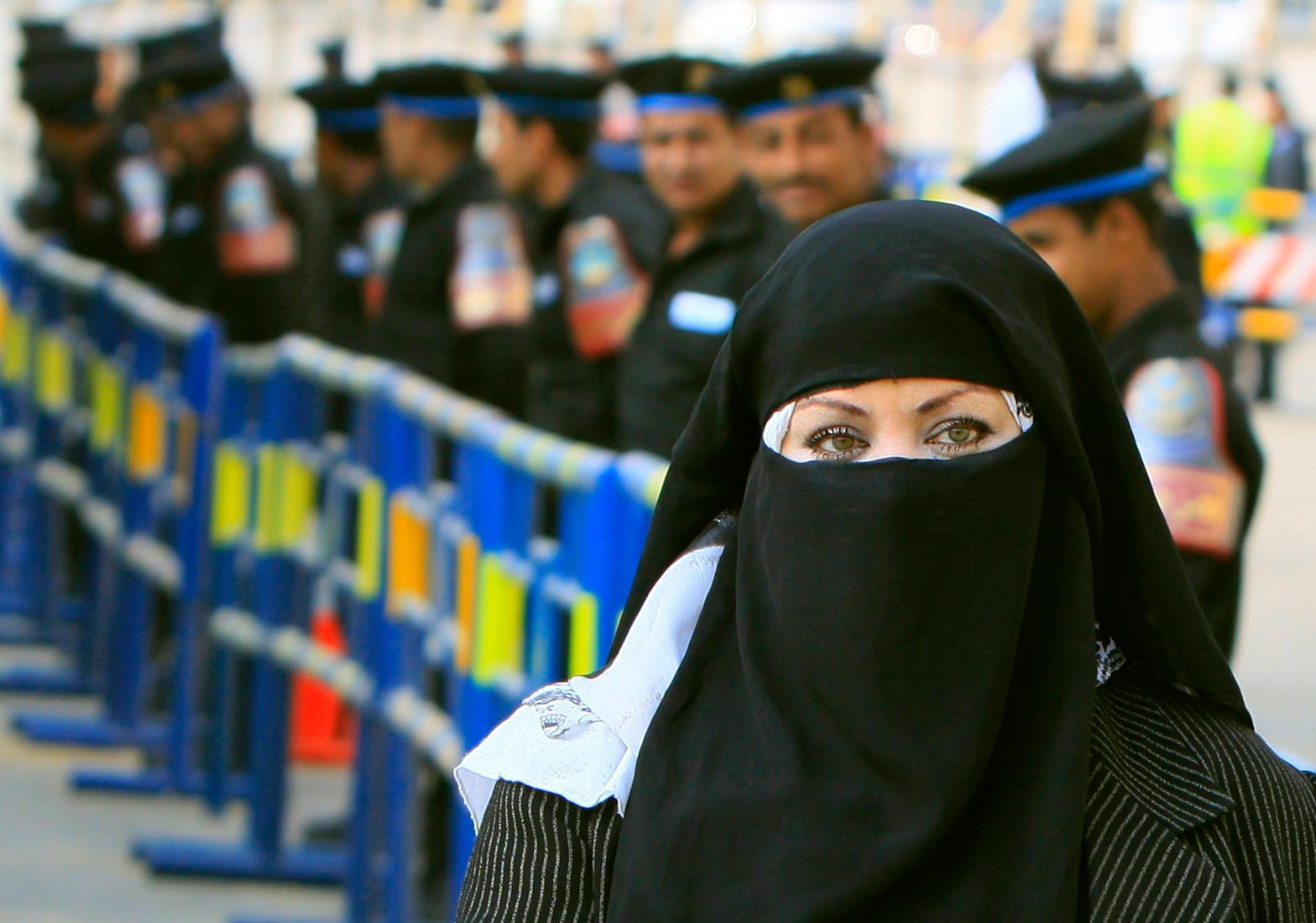 An Egyptian woman wears Islamic " Niqab" , which reveals only the eyes, walks in front of tens of soldiers securing the site of Cairo New court during the verdict of the 26 suspected Hezbollah members, accused of plotting attacks on tourists and shipping in the Suez Canal and sending operatives and explosives to Gaza to help militant groups there, in New Cairo, Egypt, Wednesday, April 28, 2010 . An Egyptian judge has sentenced three suspected Hezbollah members accused of plotting attacks on tourists, including its main Shiite leader, with life in prison. The rest of the suspects received sentences ranging from 15 years to six months. (AP Photo/Amr Nabil)       Mideast Egypt Hezbollah