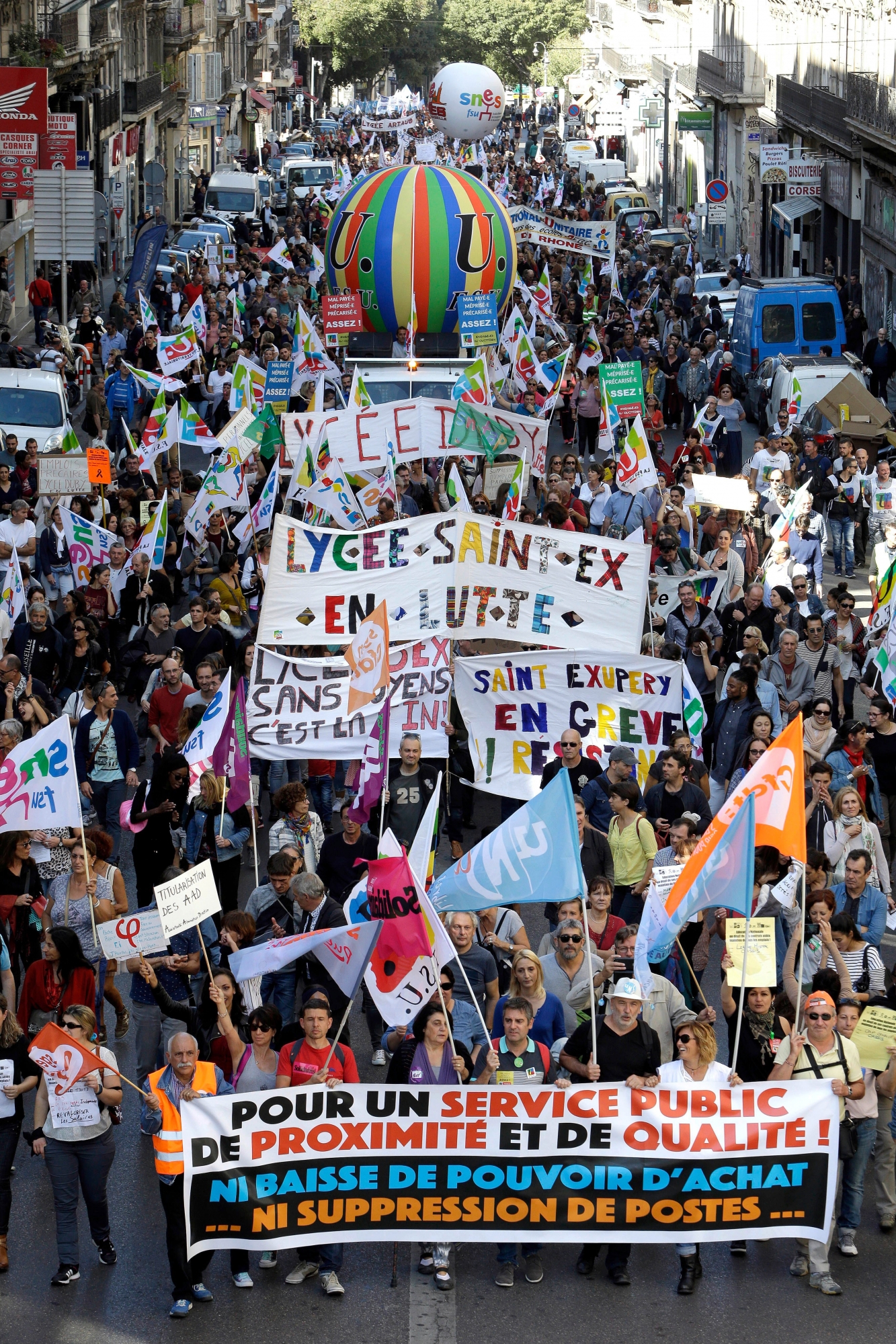 Demonstrators take the streets during a march to protest against President Emmanuel Macron's economic policies, in Paris, France, Tuesday, Oct. 10, 2017. A nationwide strike by French public sector workers on Tuesday was affecting schools, hospitals and public services and causing disruptions in domestic air traffic. Banner reads " For a closeness and quality of public services and neither reductions in purchasing power nor job cuts".(AP Photo/Claude Paris) France Strikes