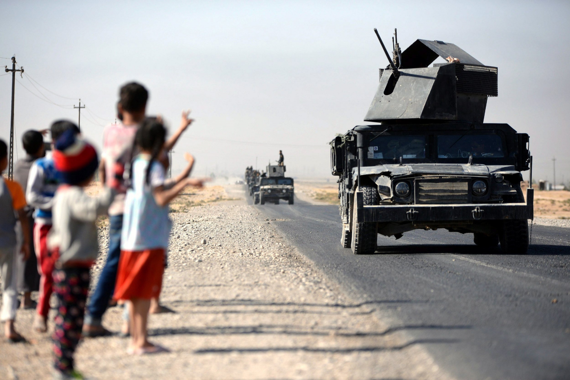 epa06269388 Children cheer as Iraqi military forces advance into central Kirkuk city, northern Iraq, 16 October 2017. Media reports state that the Iraqi military troops took over large areas from Kurdish Peshmerga militants without fighting, while an Iraqi military source announced that the Iraqi forces took several positions south of Kirkuk from Kurdish forces, including the North Gas Company station, a nearby processing plant and the industrial district south of the city. Thousends of Kurds families left the city due the fighting between Shiite militias and groups of Kurdish gunmen in southern the city, a local official said.  EPA/MURTAJA LATEEF IRAQ KIRKUK CONFLICT