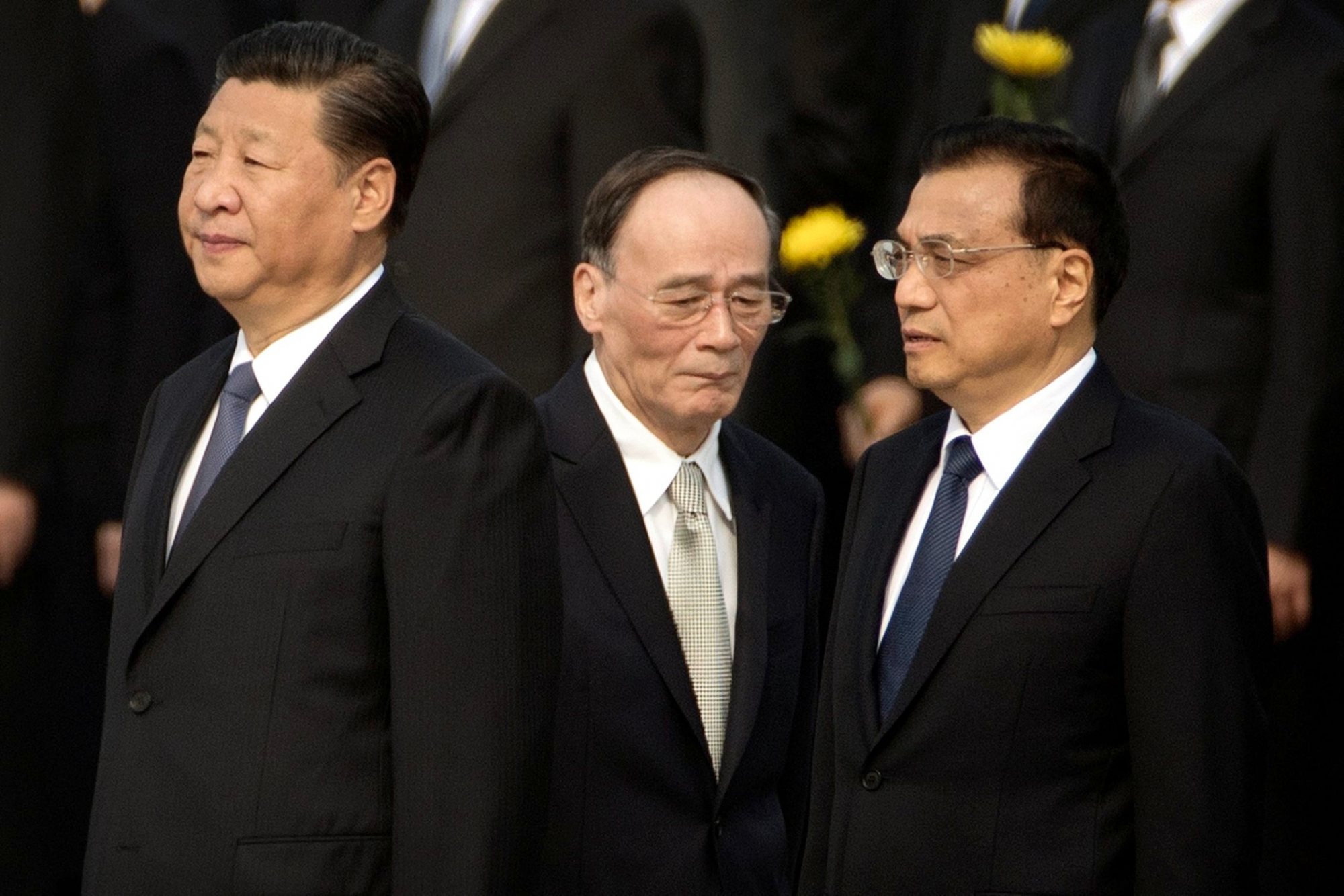FILE - In this Sept. 30, 2017 file photo, Chinese President Xi Jinping, left, Politburo Standing Committee member Wang Qishan, center, and Chinese Premier Li Keqiang attend a ceremony marking Martyrs' Day at Tiananmen Square in Beijing. Having bested his rivals, Chinese President Xi is primed to consolidate his already considerable power as the countryÄôs ruling Communist Party begins its twice-a-decade national congress on Wednesday, Oct. 18. (AP Photo/Mark Schiefelbein, File) China Party Congress