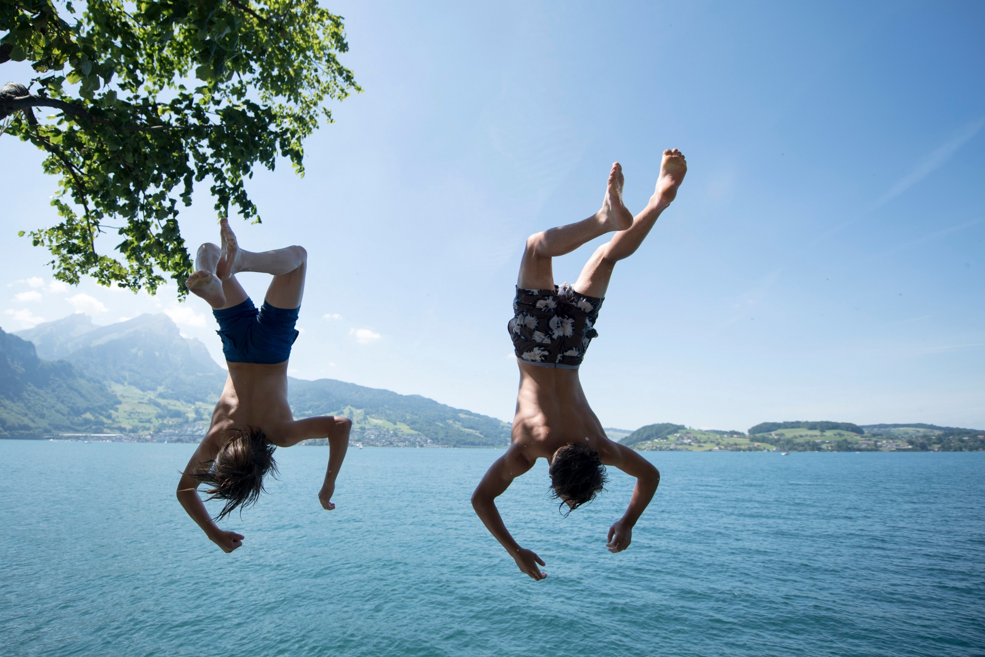 Manuel and Noah from Standsstad jump into the lake Lucerne, in Kehrsiten, Switzerland, on Saturday, June 17, 2017. (KEYSTONE/Urs Flueeler)  ..Die zwei Jungs Manuel und Noah aus Stansstad geniessen am Samstag 17. Juni 2017 bei tollstem Sommerwetter einen Sprung von der Kehrsitenstrasse in den Vierwaldstaettersee. (KEYSTONE/Urs Flueeler) SCHWEIZ FRUEHLING VIERWALDSTAETTERSEE