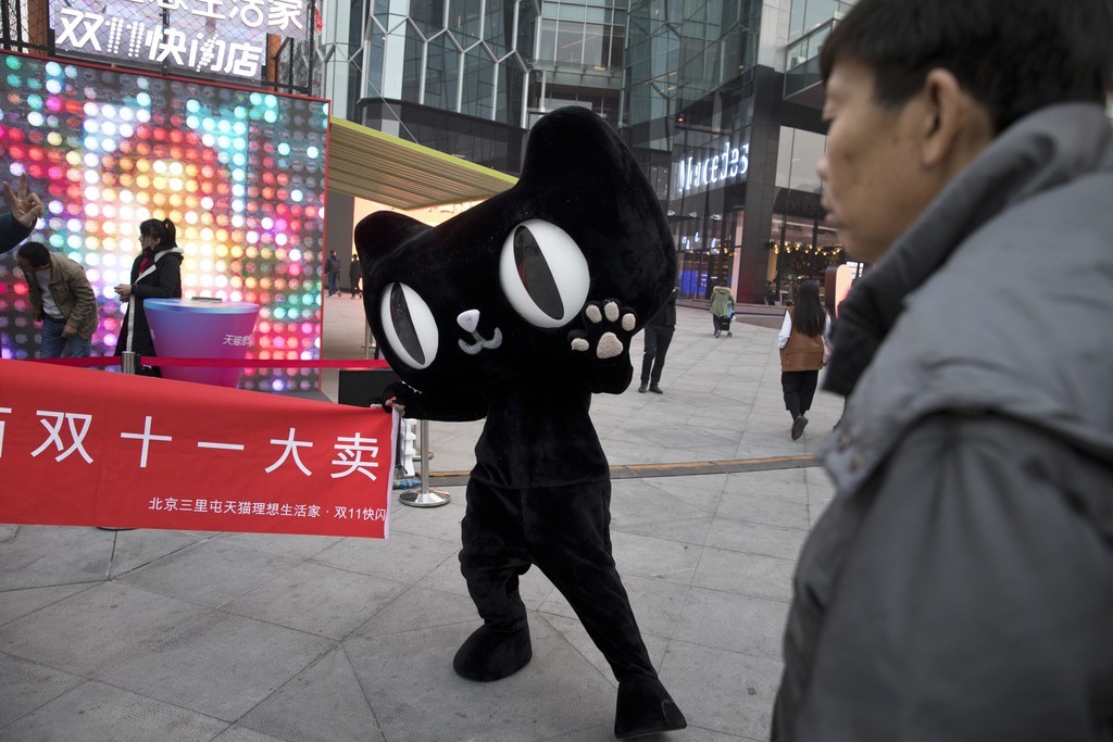 Dans une rue de Pékin, la mascotte d’un site d'achat en ligne brandit une bannière avec le mot "Double 11 grande vente" lors d'un événement promotionnel de la "Journée des célibataires".