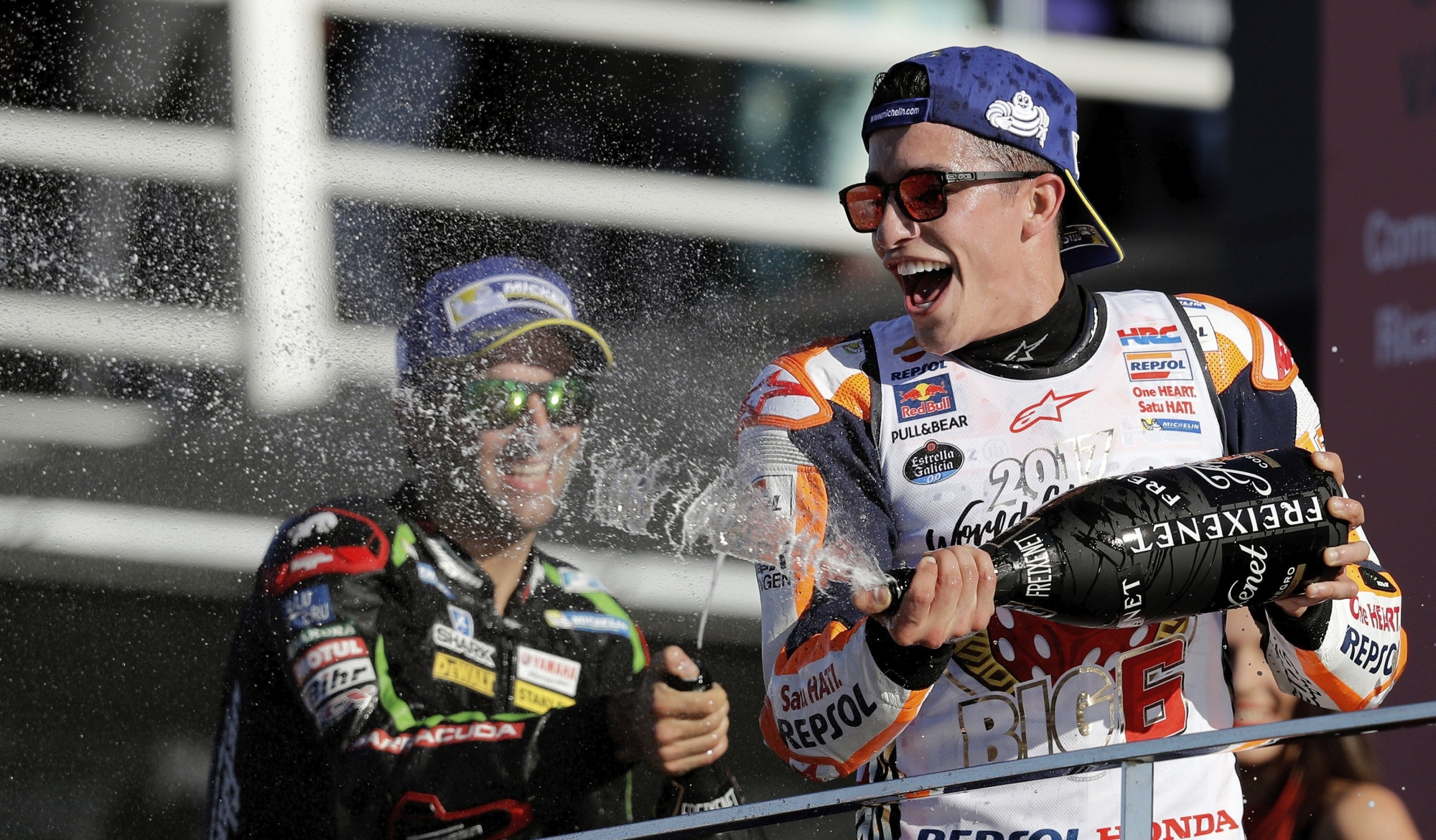 epa06324659 Third placed Spanish MotoGP rider Marc Marquez (R) of Repsol Honda team celebrates on podium after the Comunitat Valenciana motorcycling Grand Prix at Ricardo Tormo track in Cheste, Valencia, eastern Spain, 12 November 2017. Marquez clinched his fourth MotoGP world title.  EPA/Manuel Bruque SPAIN MOTORCYCLING GRAND PRIX