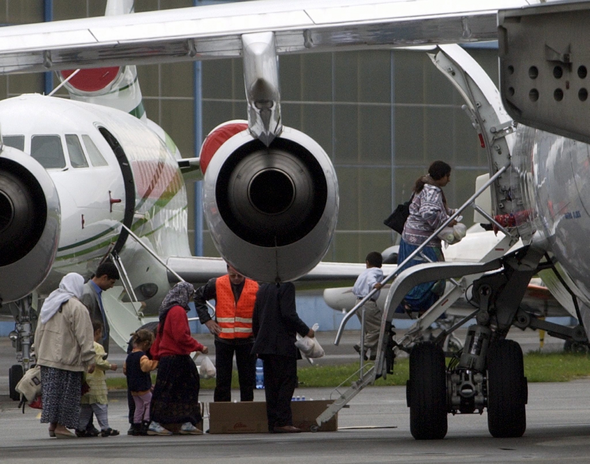 Eine 78 Personen starke Gruppe  von Roma wird am Donnerstag, 10. Oktober 2002, aus dem Fluechtlingsempfangsheim Chiasso via  Flugzeug von Lugano-Agno aus nach Rumaenien geflogen. Bild: Muetter und  Kinder beim besteigen des gecharterten Jumbolino in Agno. (KEYSTONE/Karl Mathis) SCHWEIZ ROMA AUSSCHAFFUNG