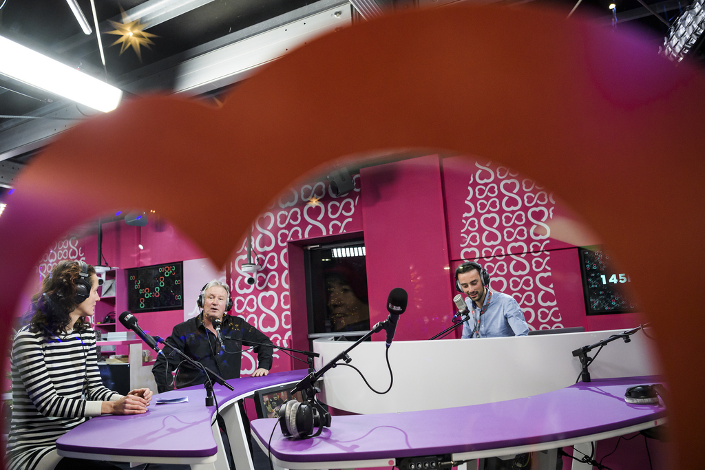 Depuis la gauche, Pauline Seiterle, Philippe Robin, et Jonas Schneiter, animateurs de la RTS, parlent dans le studio apres leur entrée lors du lancement de la 2ème édition de l'opération caritative "Coeur a Coeur".