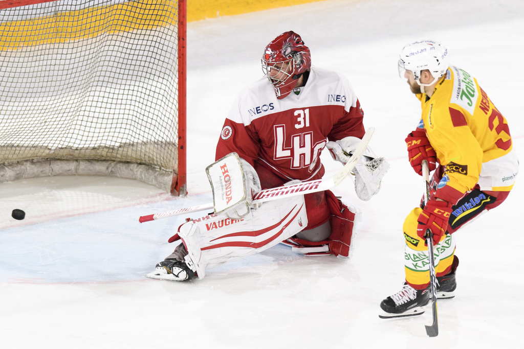 L'attaquant de Langnau Benjamin Neukom, marque son penalty contre le gardien lausannois Sandro Zurkirchen lors de la séance de tirs au but.