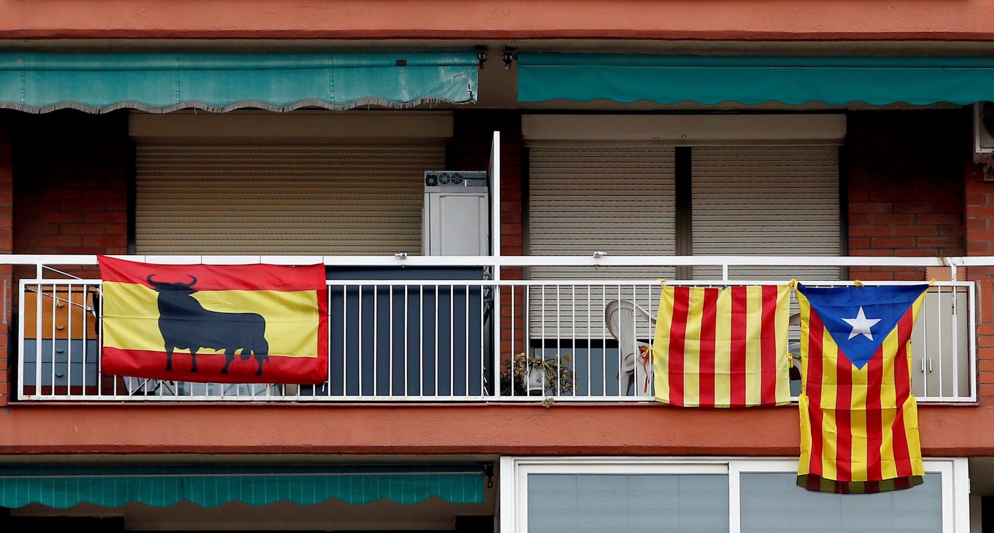 epa06399889 Spanish and Catalonian pro-independence flags hang from balconies in Badalona, Catalonia, northern Spain, 20 December 2017, a day before the Catalonian regional elections, scheduled for 21 December 2017. Regional elections in Catalonia will be held to elect all 135 seats in the Catalan regional parliament, as the Spanish central government applied article 155 of the Constitution following the regional parliament's unilateral declaration of independence.  EPA/ALBERTO ESTEVEZ SPAIN CATALONIA ELECTIONS
