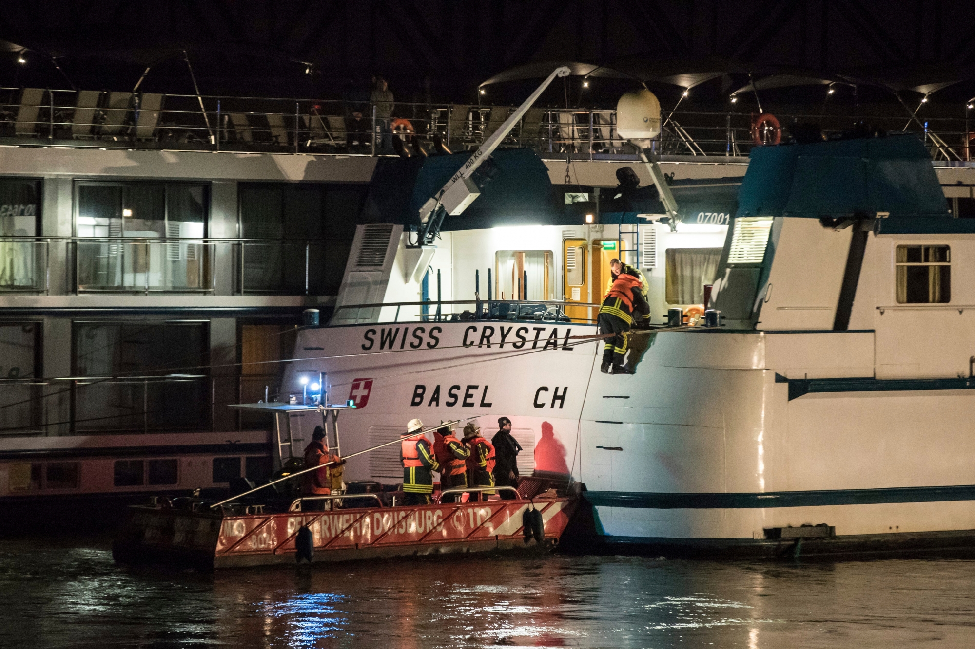 In this Dec. 26, 2017 photo rescuers arrive at a tourist ship  in Duisburg, Germany. A tourist ship has struck a highway bridge on the Rhine river in western Germany. Police say 27 people are injured. The Swiss Crystal, which news agency dpa reports was en route to the Netherlands, hit a pillar of the bridge near Duisburg on Tuesday evening. (Marcel Kusch/dpa via AP) GERMANY SHIP HITS BRIDGE