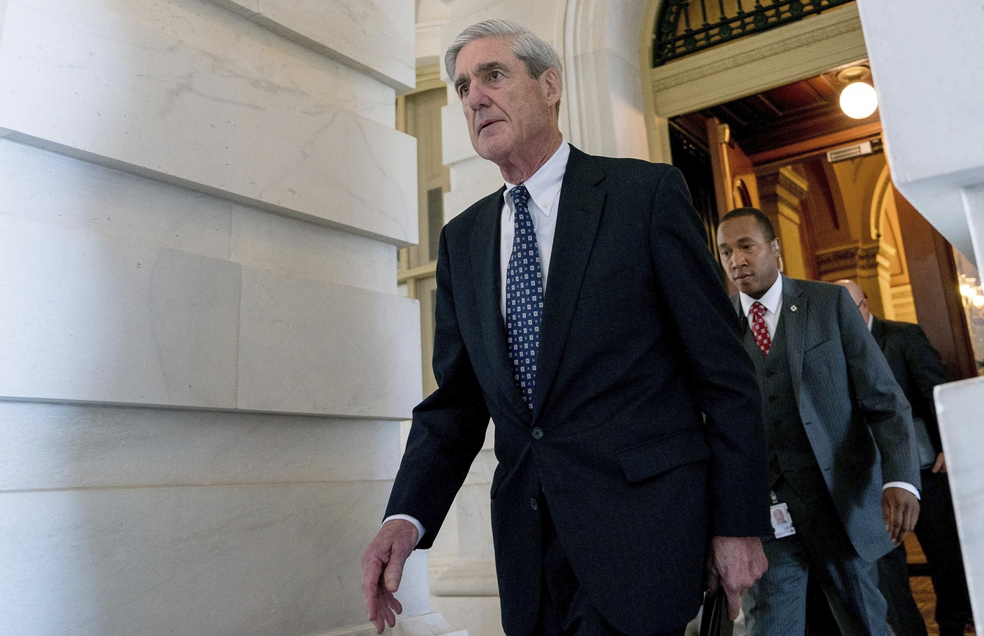FILE - In this June 21, 2017, file photo, former FBI Director Robert Mueller, the special counsel probing Russian interference in the 2016 election, departs Capitol Hill in Washington. President Donald Trump's transition organization is arguing that a government agency improperly turned over a cache of emails to Mueller as part of his investigation into contacts between Trump associates and Russia. The complaint by the transition team is the latest attempt to undermine Mueller's investigation in the public sphere. (AP Photo/Andrew Harnik, File) TRUMP RUSSIA PROBE EMAILS Q&A